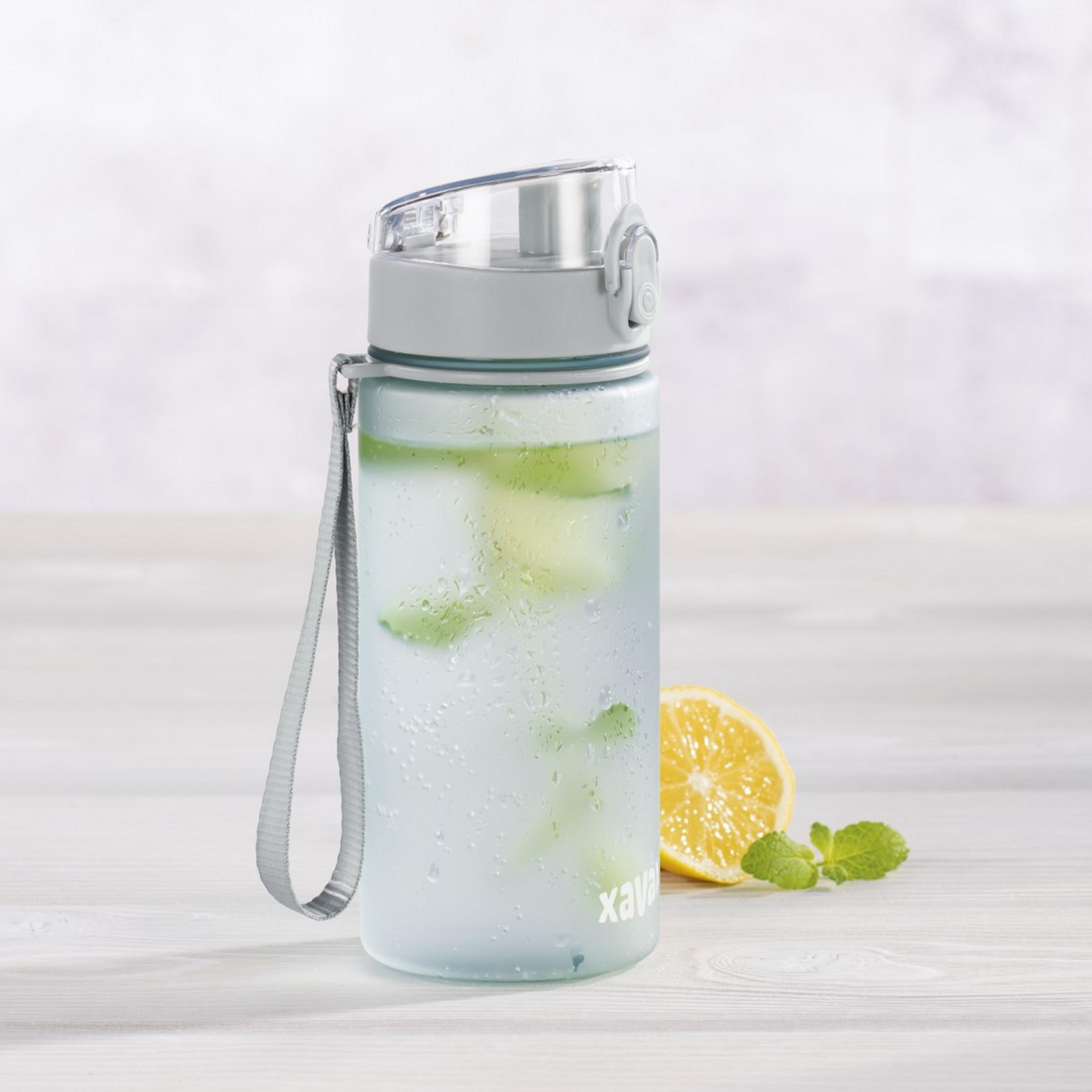 Eine durchsichtige Wasserflasche mit Minze und Zitrone auf einem Holztisch.