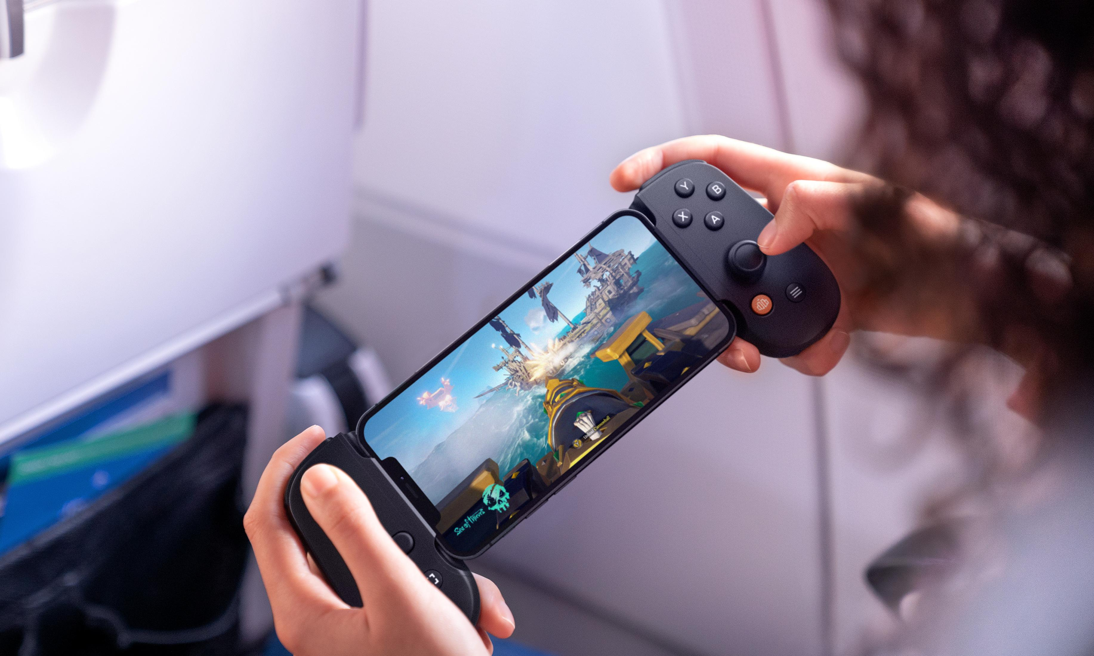 Persoon speelt piratenschipspel op telefoon met controller in een vliegtuig.
