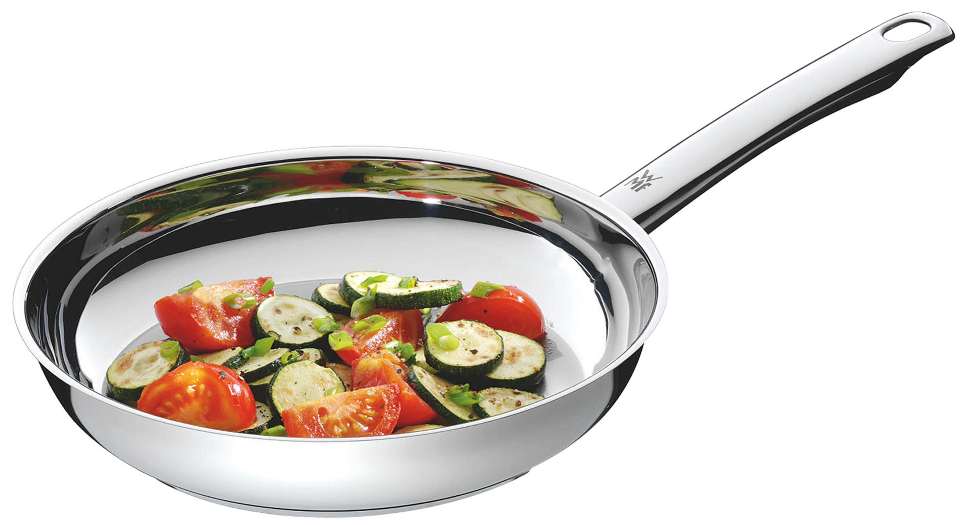 Ein glänzender Metallpfanne mit Tomaten und Zucchini-Scheiben.