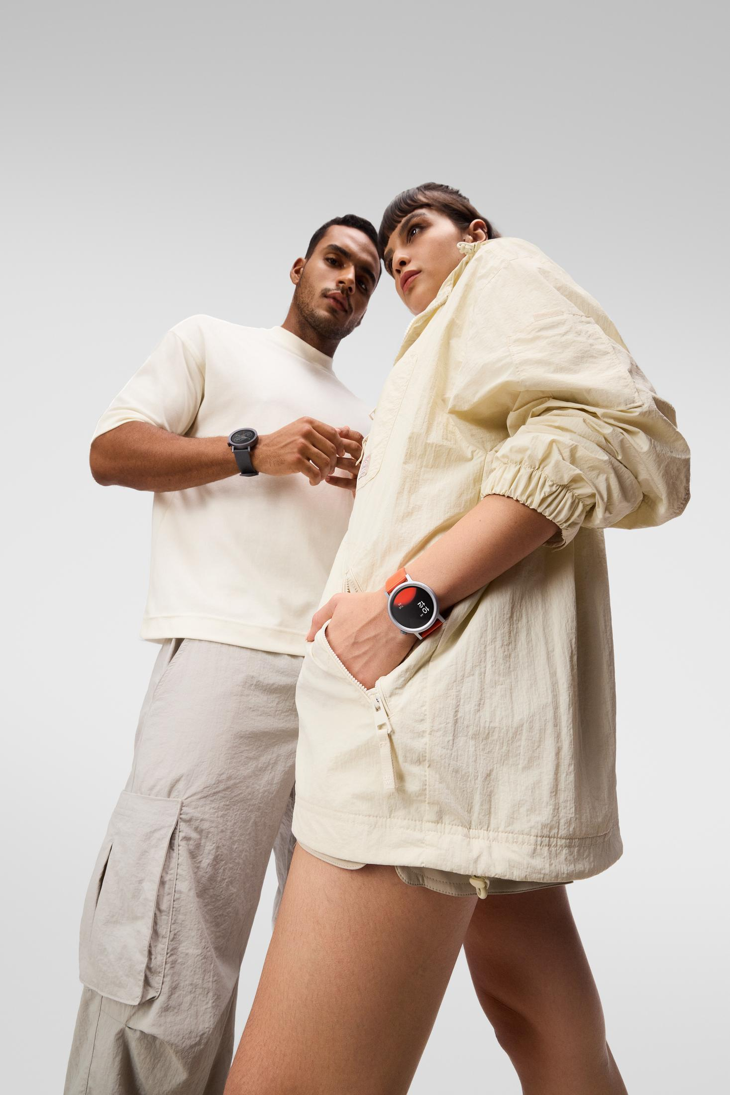 Mężczyzna i kobieta w zegarkach na szarym tle.