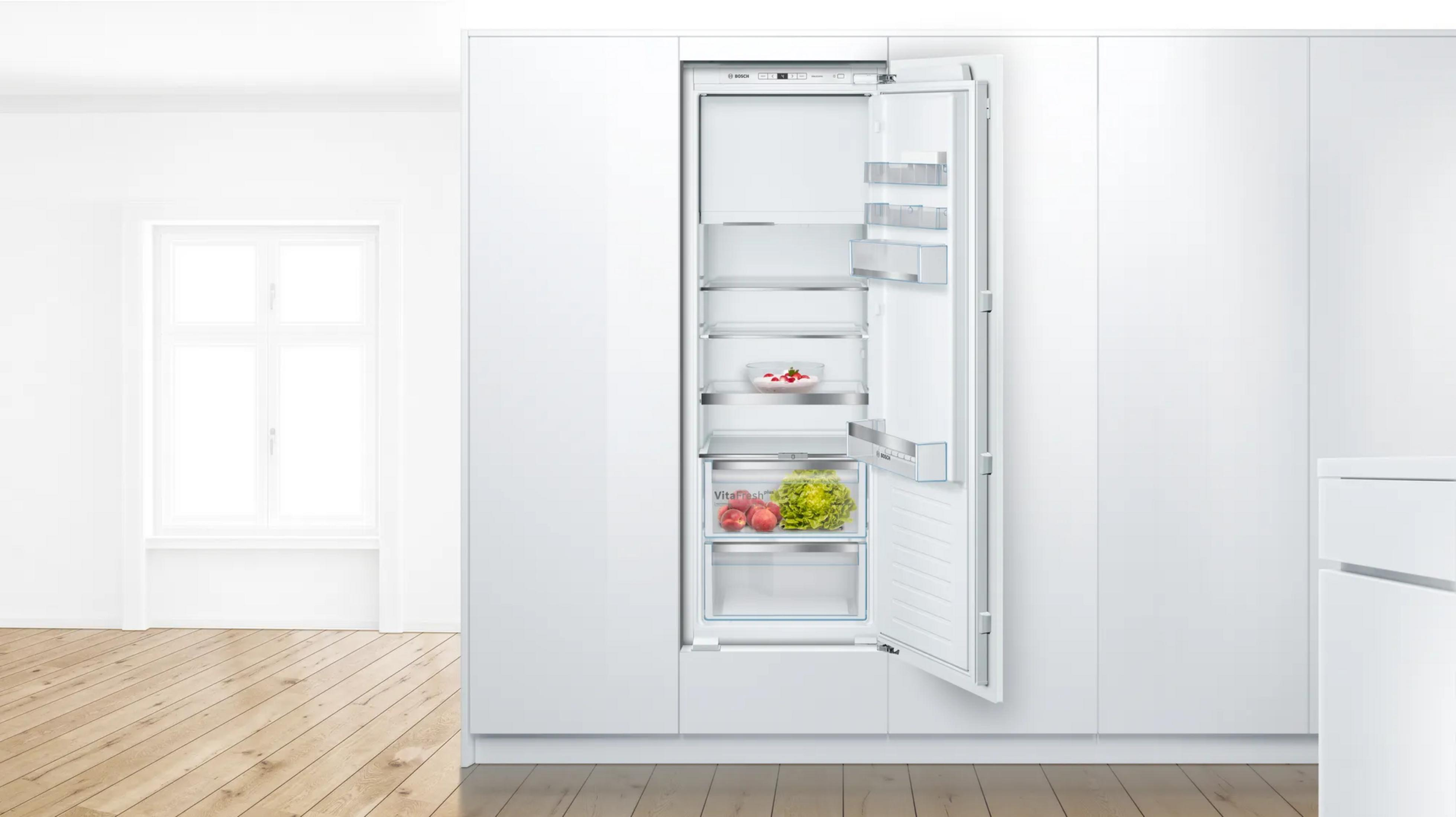 Ein offener weier Kõhlschrank mit Obst und Gemüse.