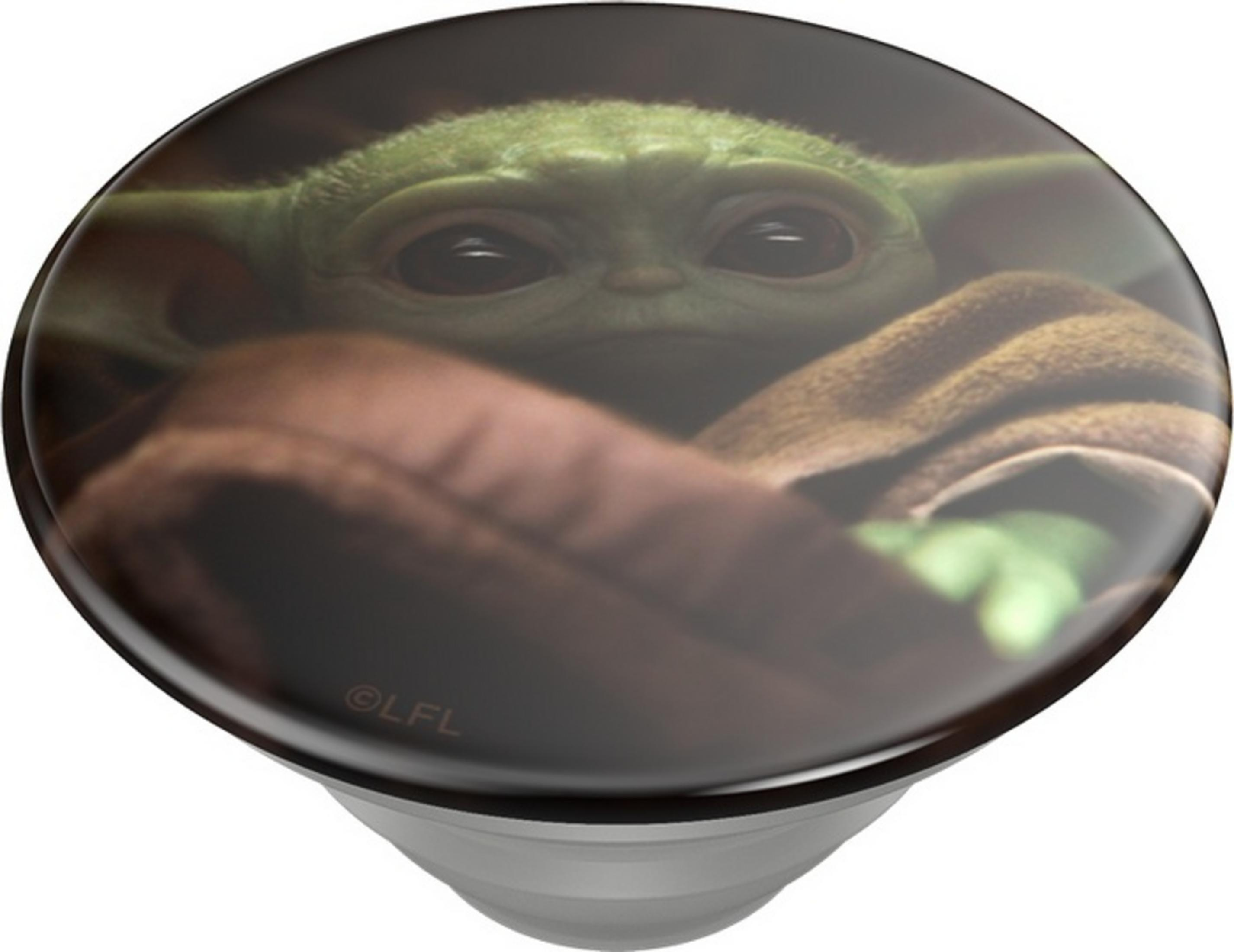 Baby Yoda, in braune Decke gehüllt, schaut mit großen Augen.