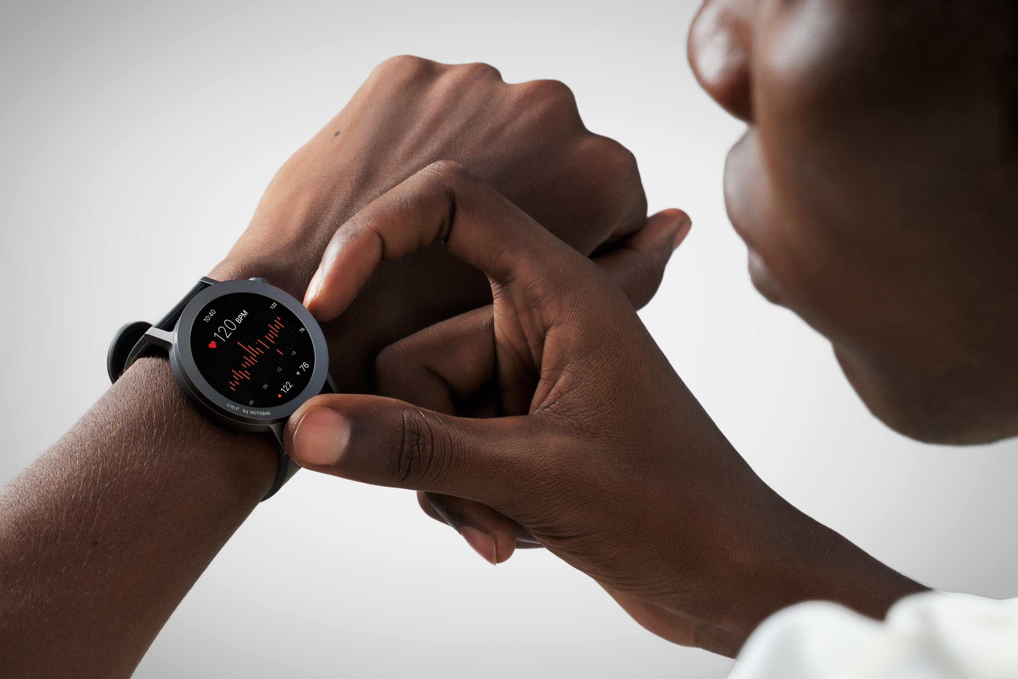 Osoba sprawdza swój smartwatch wyświetlający dane tętna.