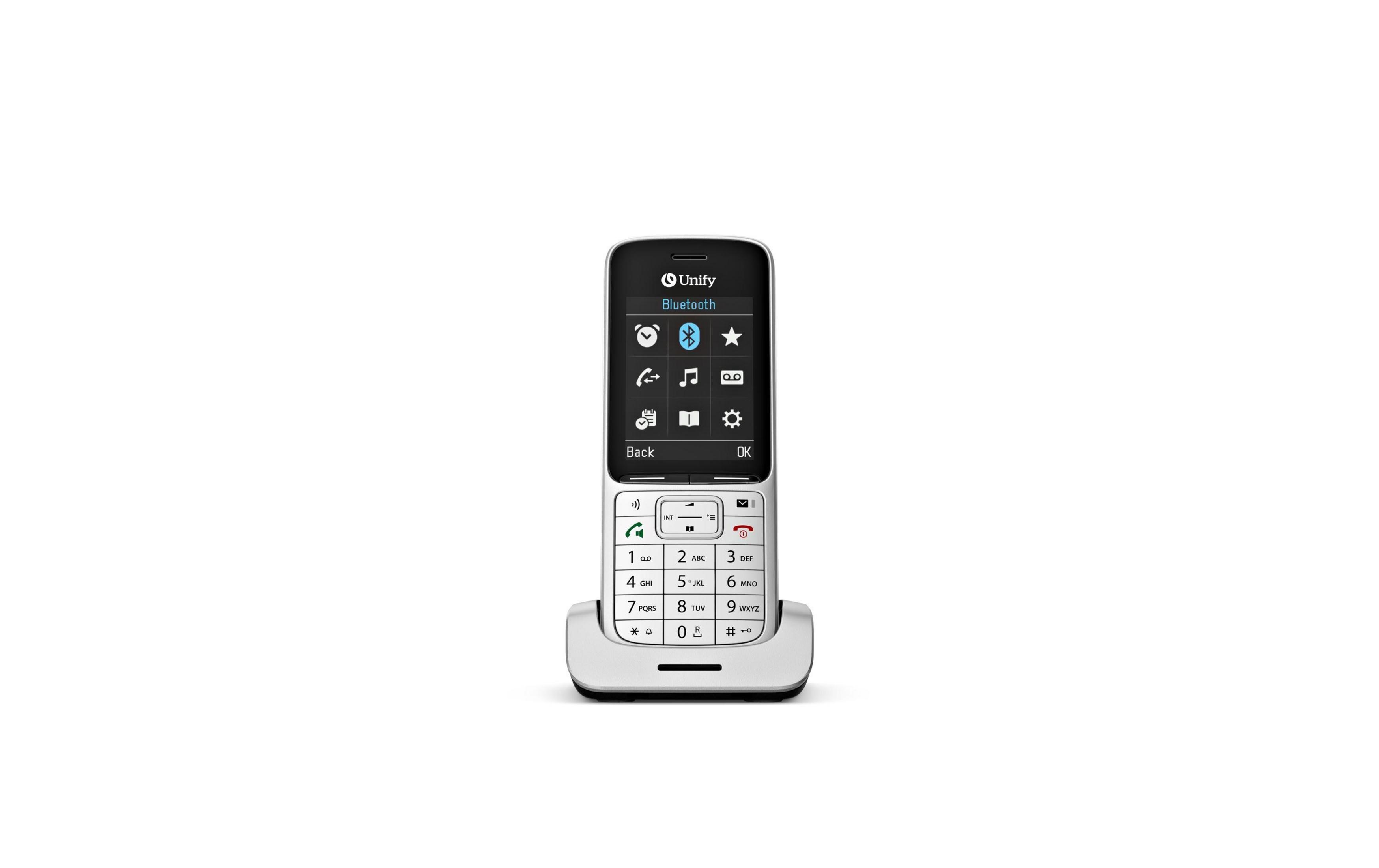 Un telefono cordless bianco con schermo e tastiera poggia su una base di ricarica.