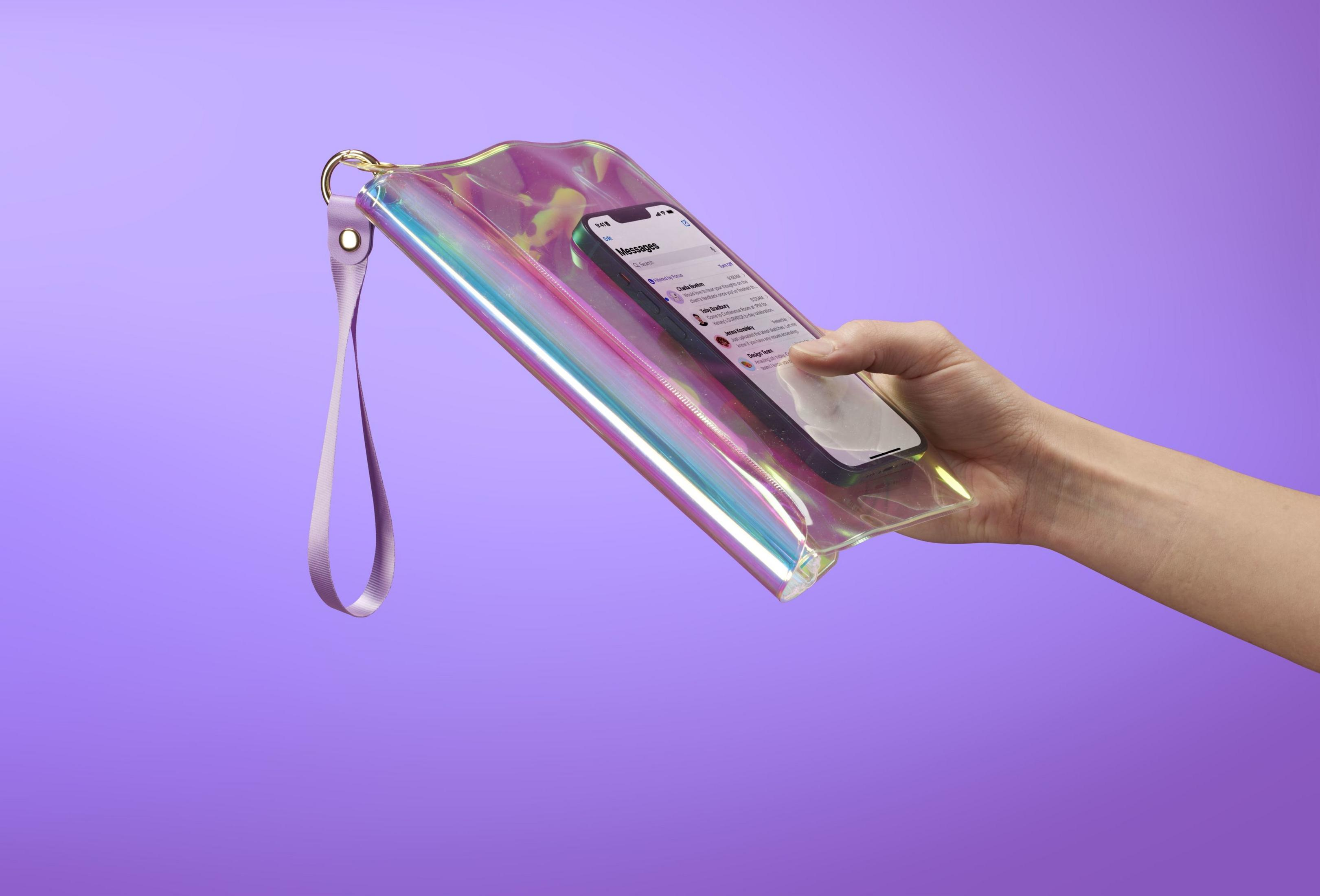 Mano tiene borsa trasparente con telefono, sfondo viola.
