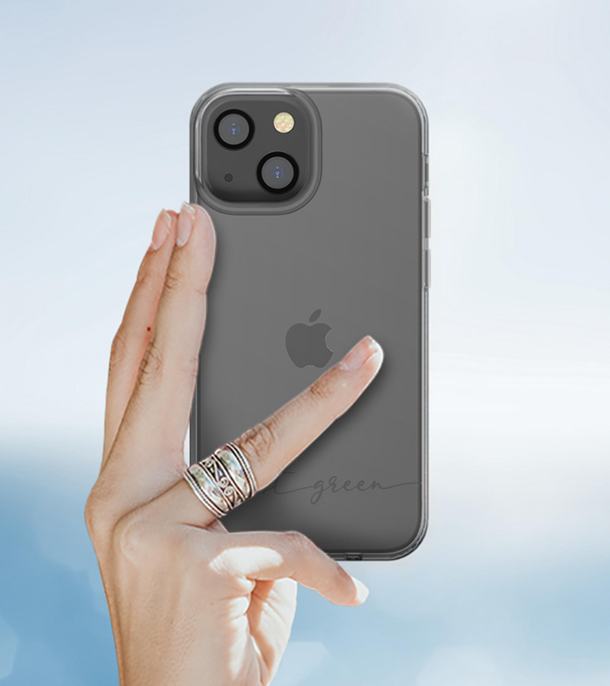 Eine Hand mit Ringen hält ein transparentes Handy mit Apple-Logo und Schriftzug.