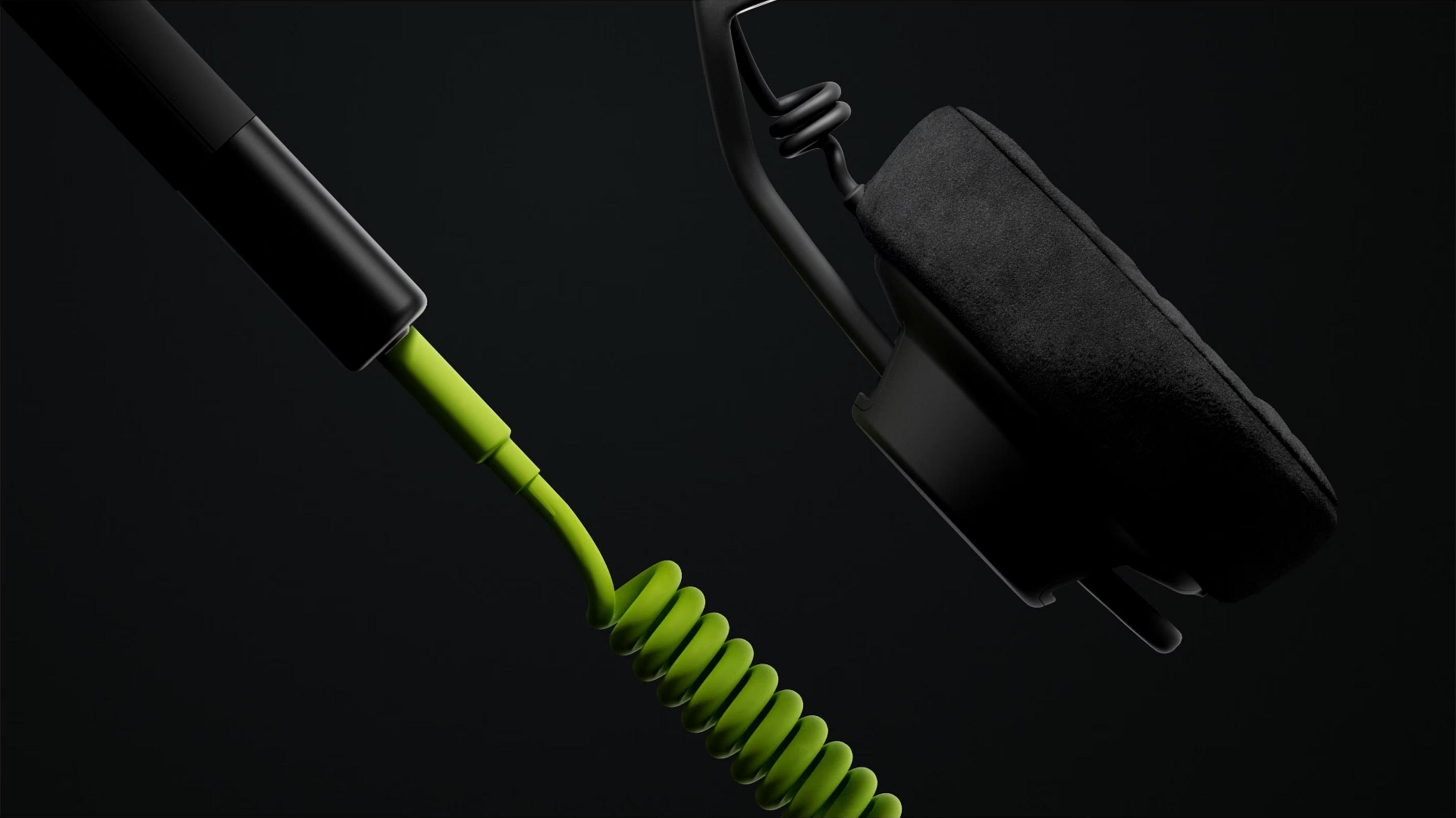 Ein schwarzes Headset mit einem leuchtend grünen Spiralkabel auf schwarzem Hintergrund.