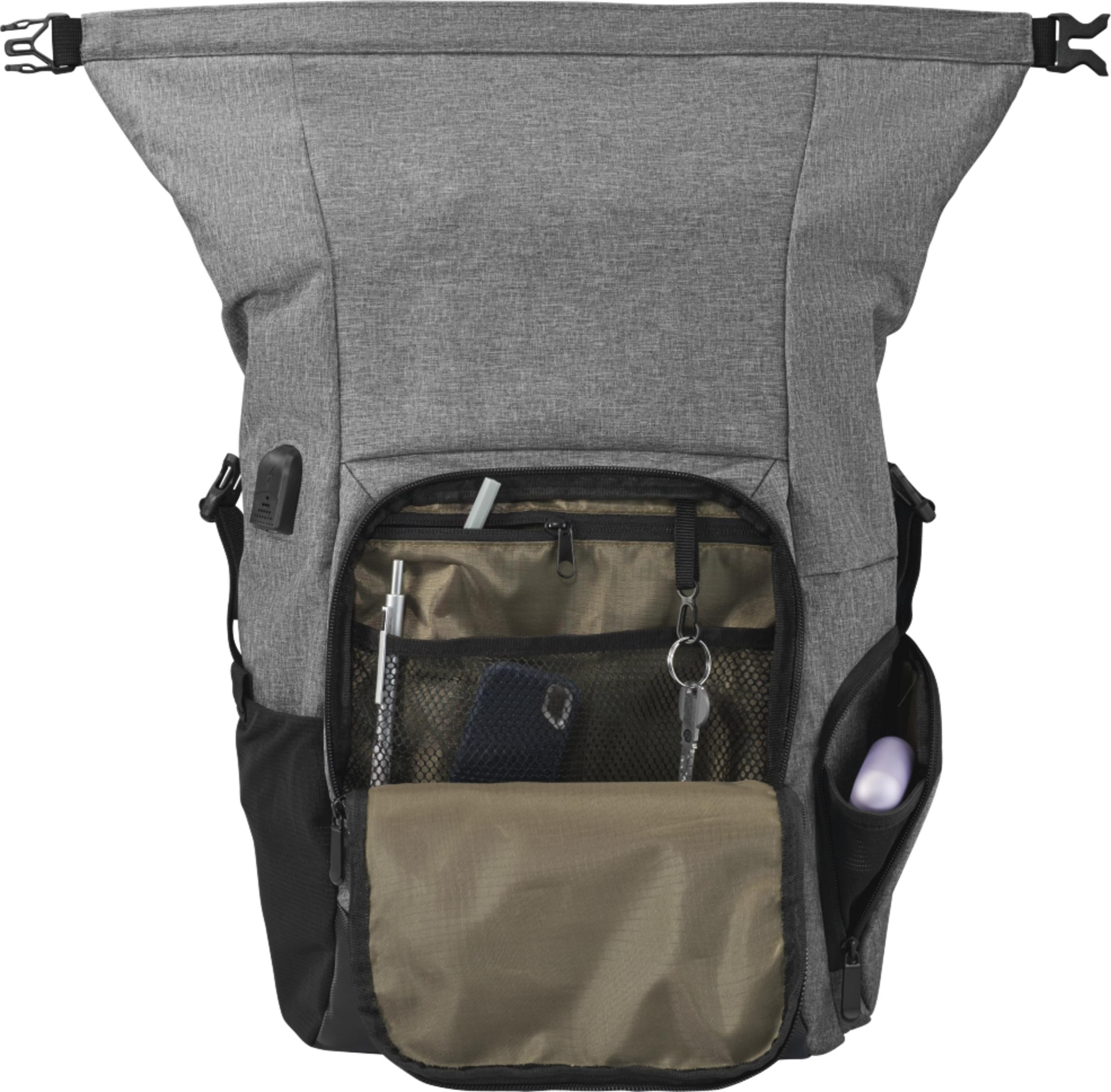 Szary plecak z otwartymi kieszeniami zawierającymi przedmioty, takie jak klucze i telefon.