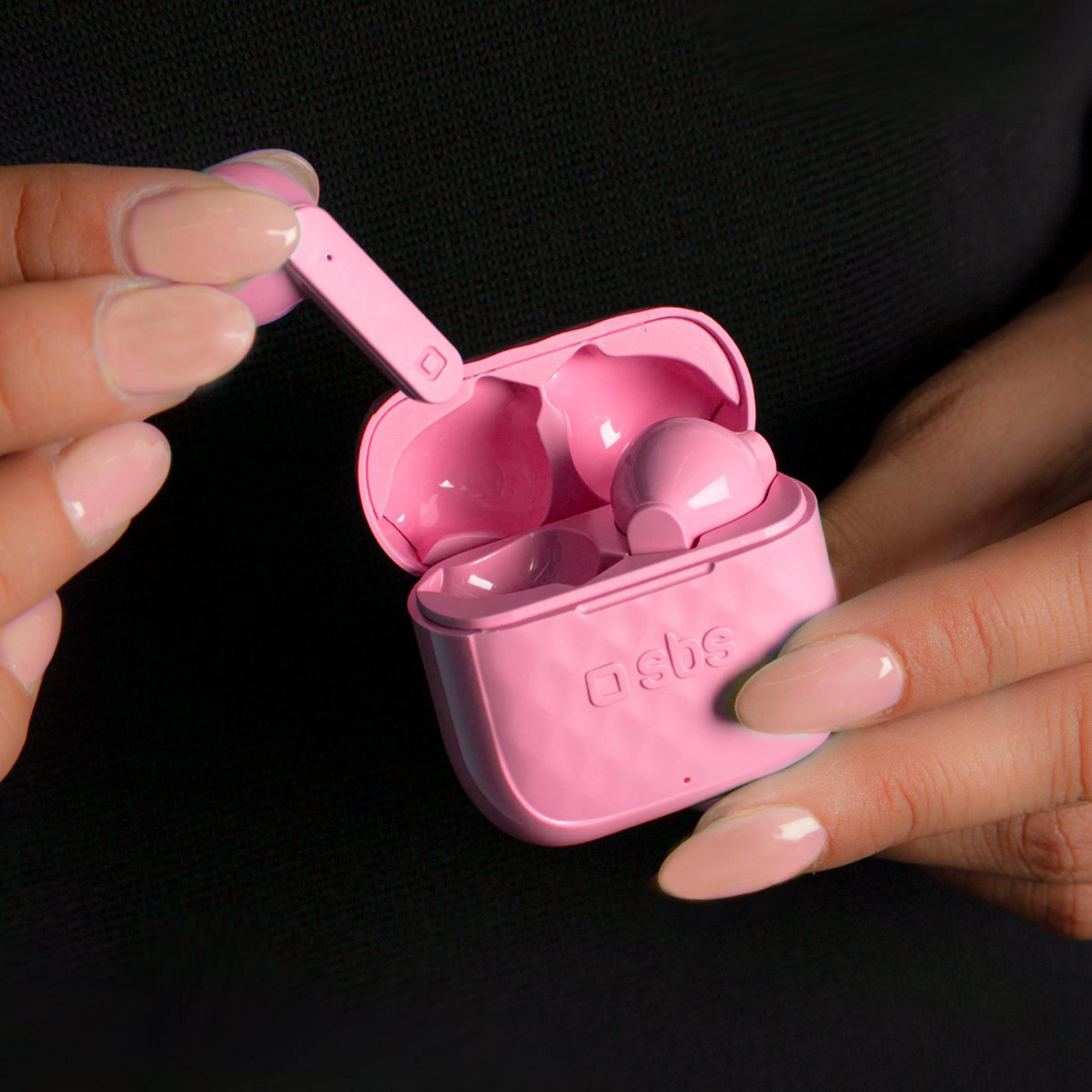 Mani che tengono una custodia di ricarica rosa per auricolari wireless. Un auricolare viene inserito.