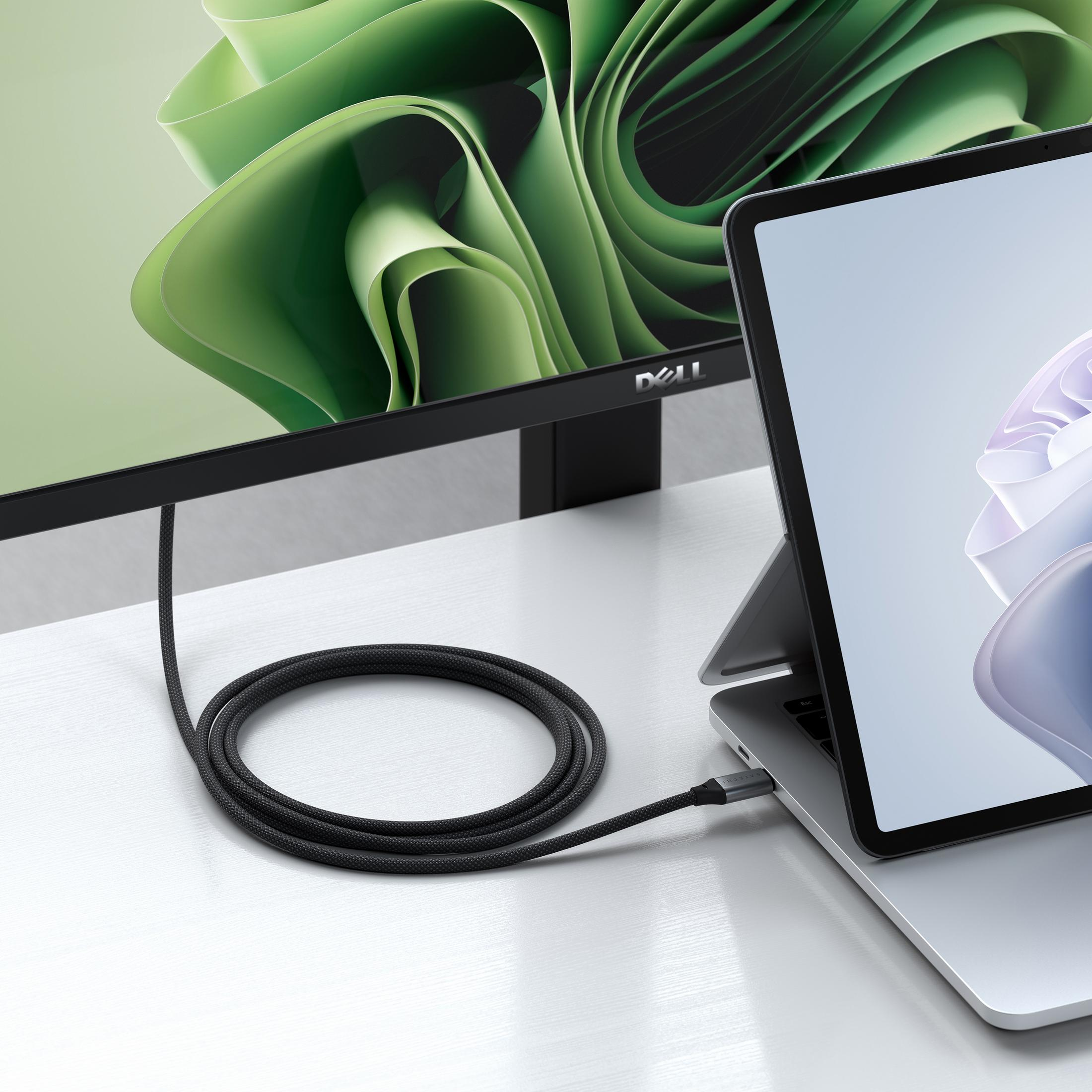 Ein schwarzes Kabel verbindet einen Laptop mit einem Dell-Monitor. Grüne und blaue Grafiken sind zu sehen.