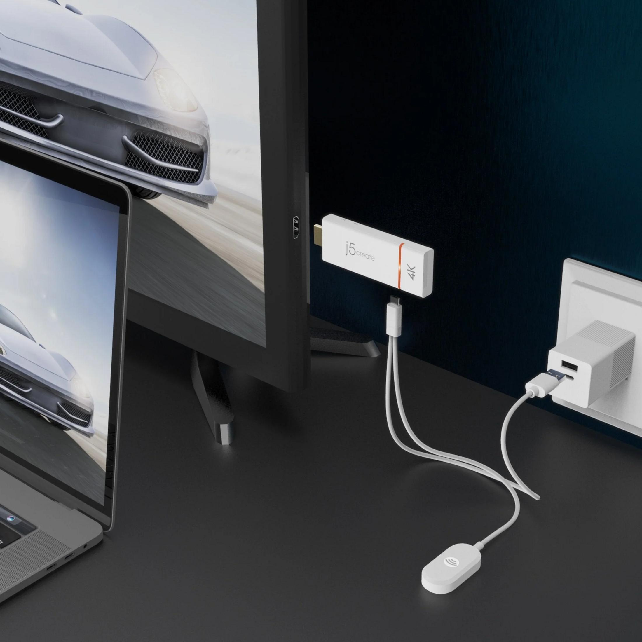 Ein Laptop und ein Monitor zeigen ein Auto. Ein 4K-Dongle ist angeschlossen.