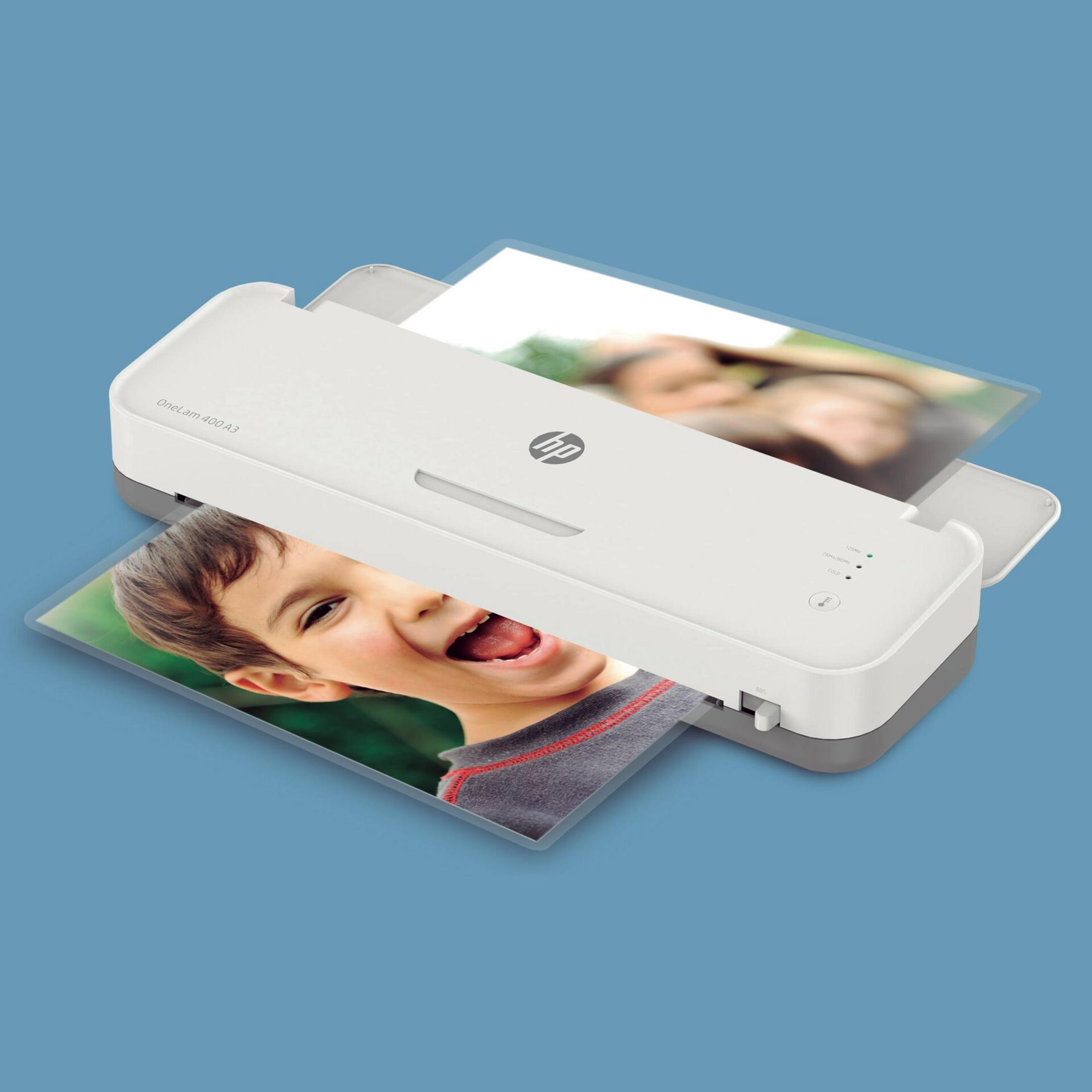 Biały laminator z uśmiechniętym chłopcem na laminowanym zdjęciu.