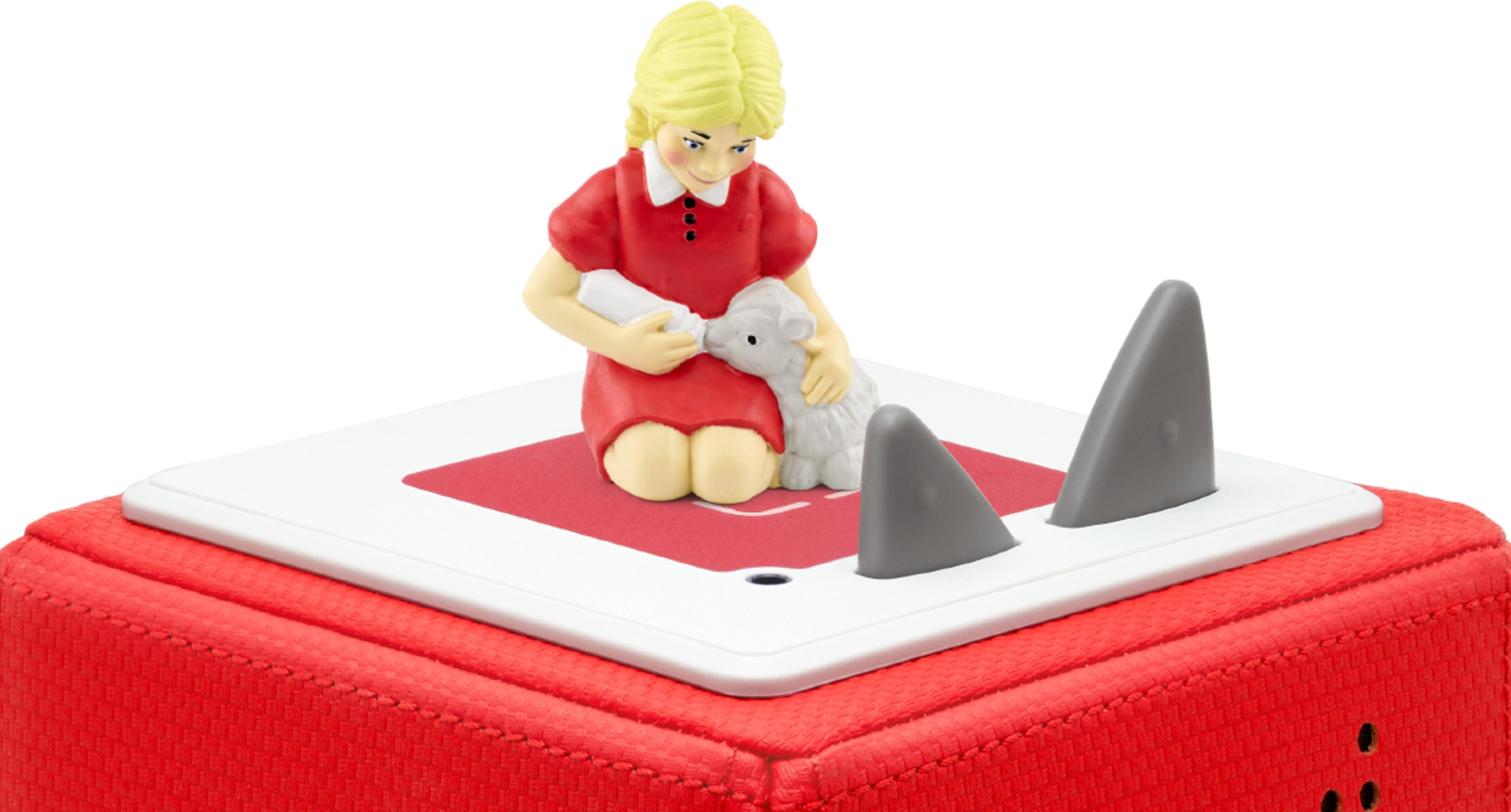 Mädchen in Rot füttert Lamm auf Spielzeug mit Haifischflossen.