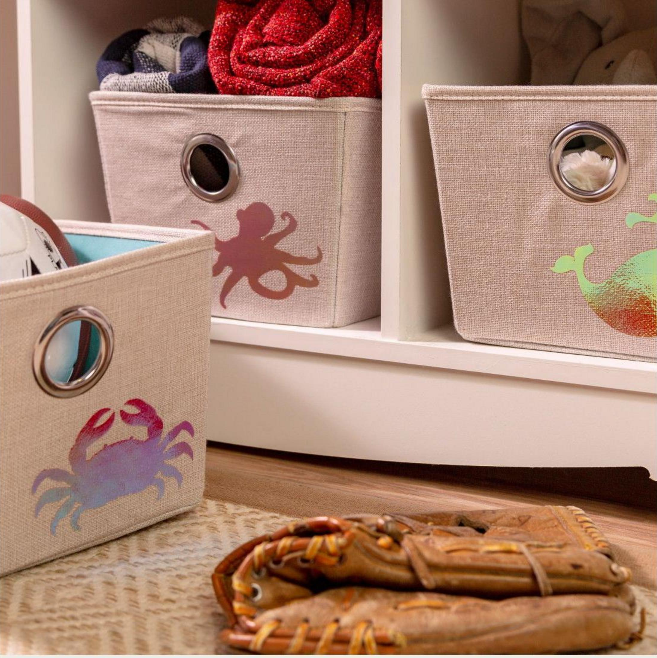 Beige Aufbewahrungsboxen mit Tiermotiven (Krabbe, Oktopus, Wal) und ein Baseballhandschuh.