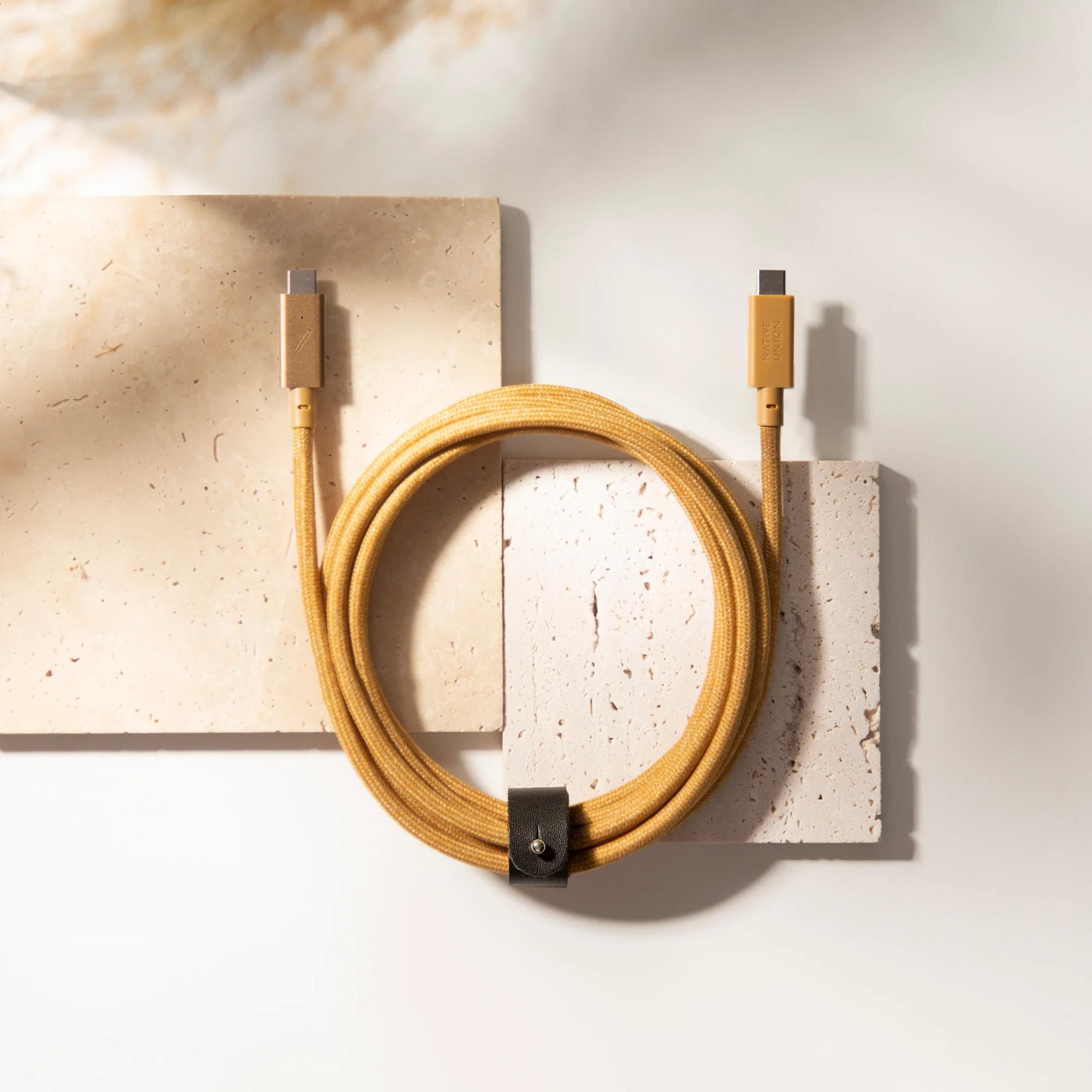 Un cavo USB-C giallo con cinturino in pelle nera poggia su lastre.