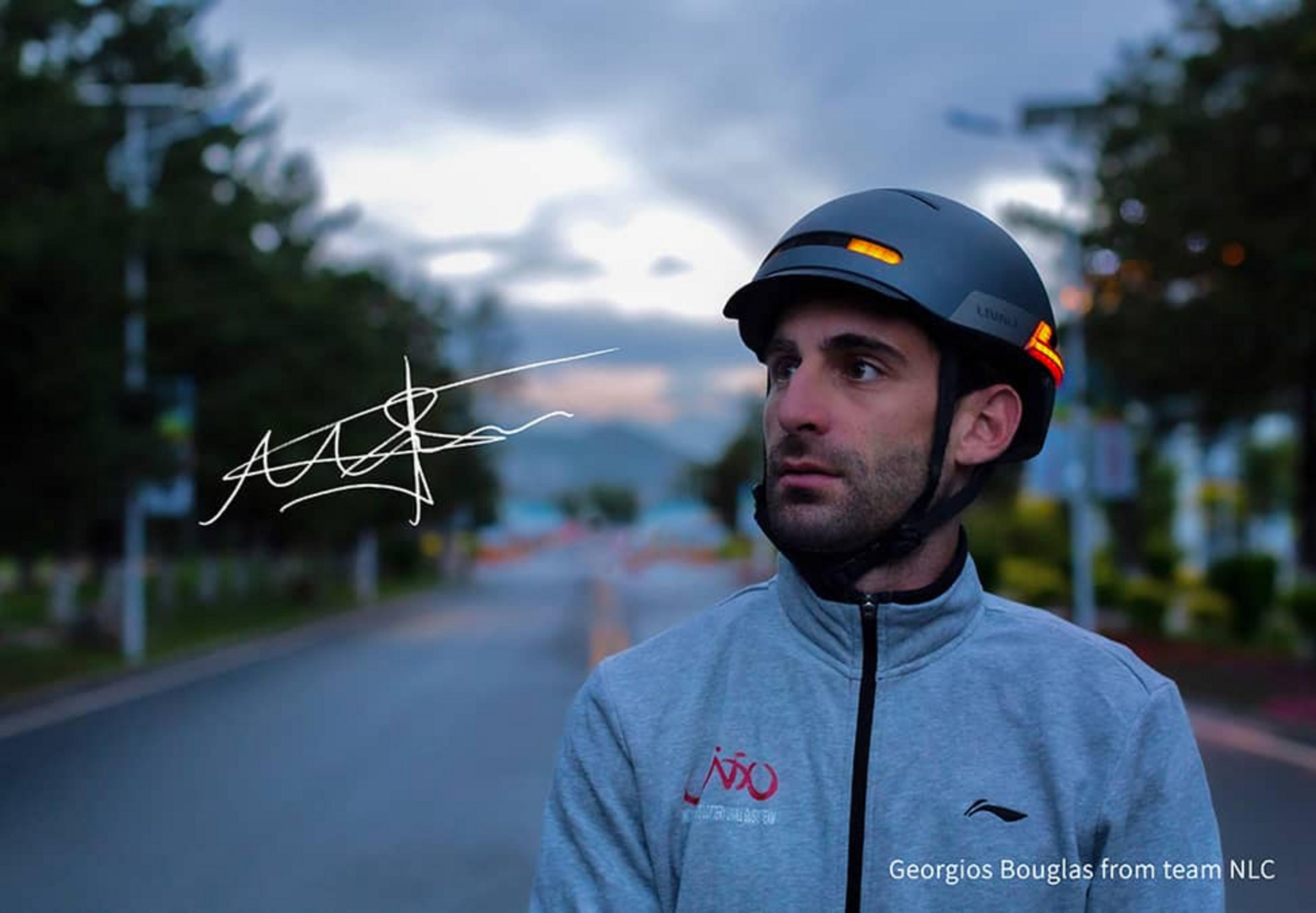 Mann mit Helm und Jacke auf einer Straße, mit Lichtern am Helm.