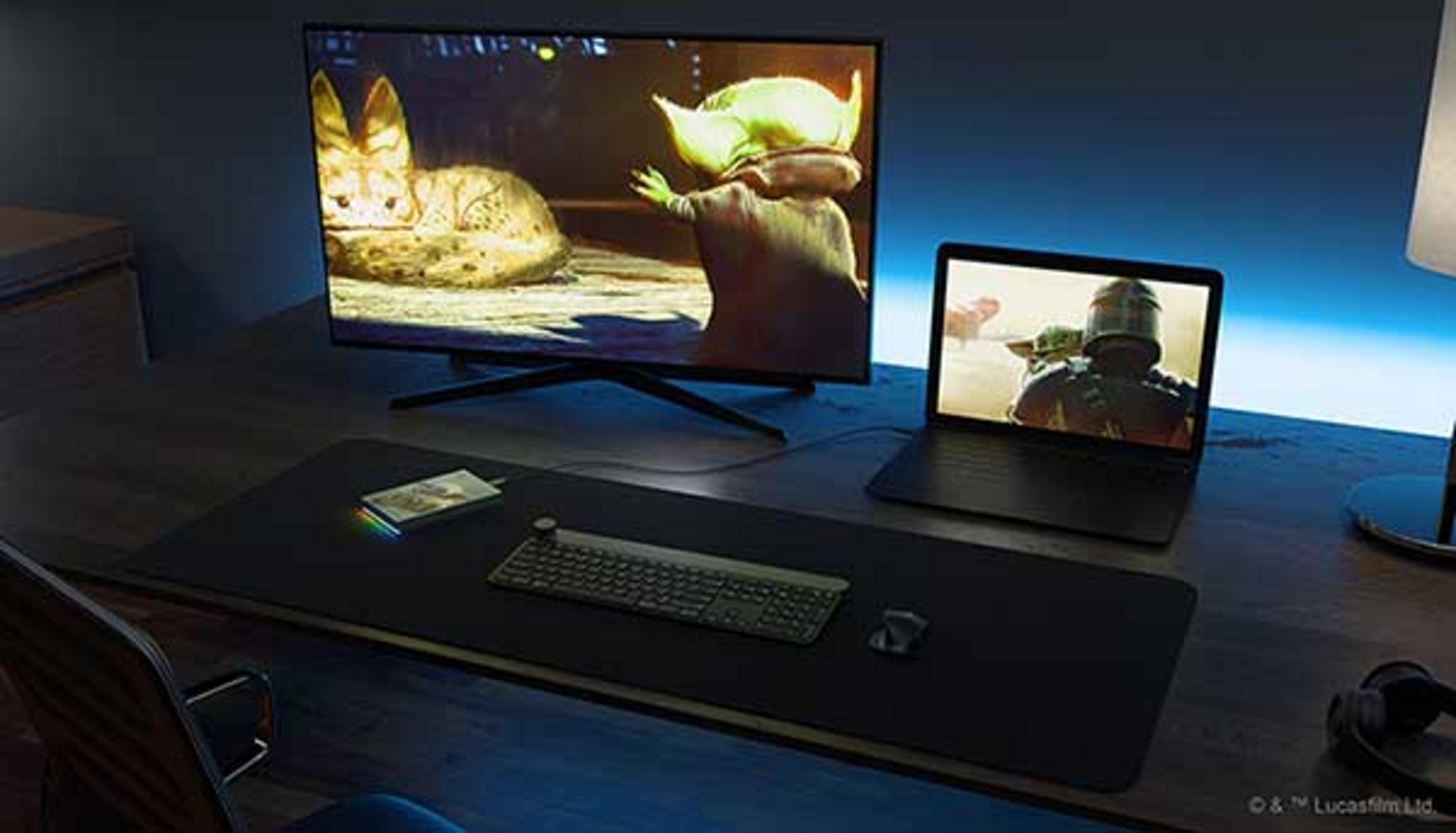 Ein Schreibtisch mit zwei Bildschirmen, die Star Wars zeigen, Tastatur, Maus und Kopfhörer.