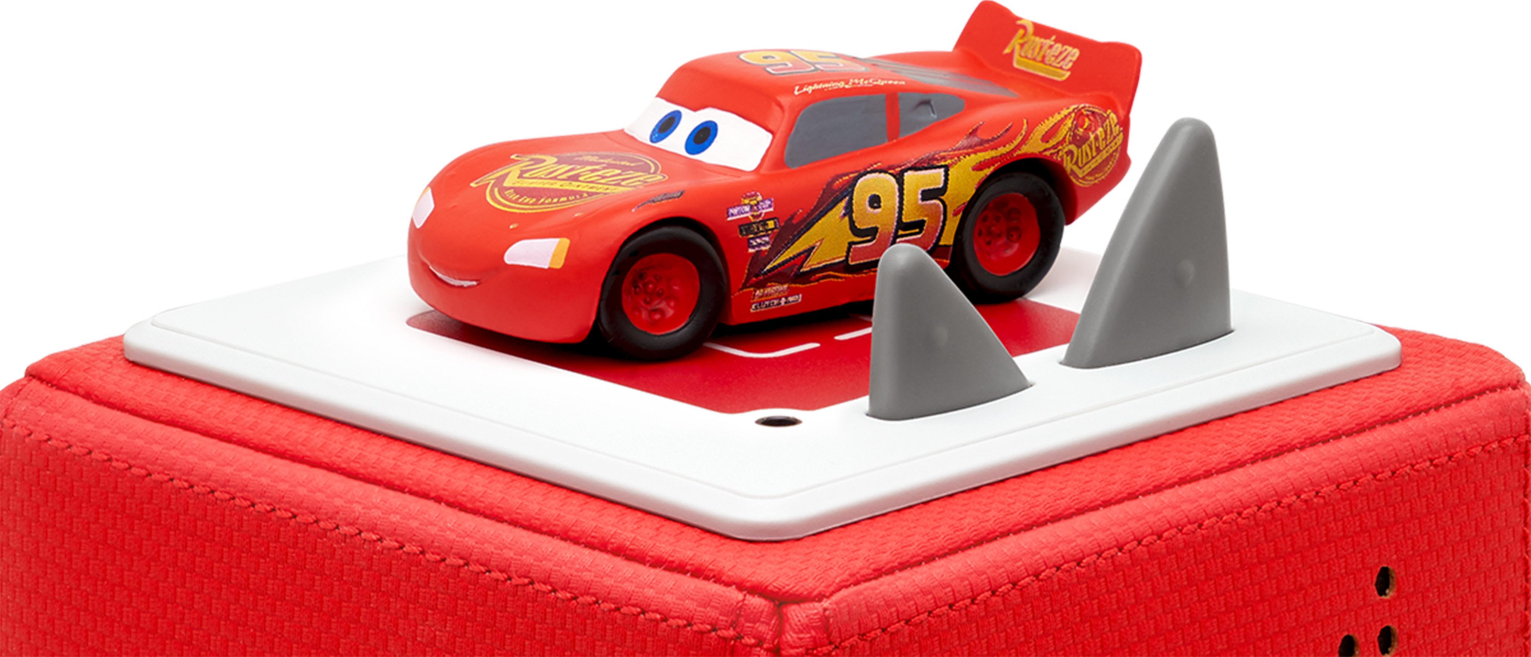 Ein rotes Spielzeugauto "Lightning McQueen" mit der Nummer 95 steht auf einer weißen Plattform.