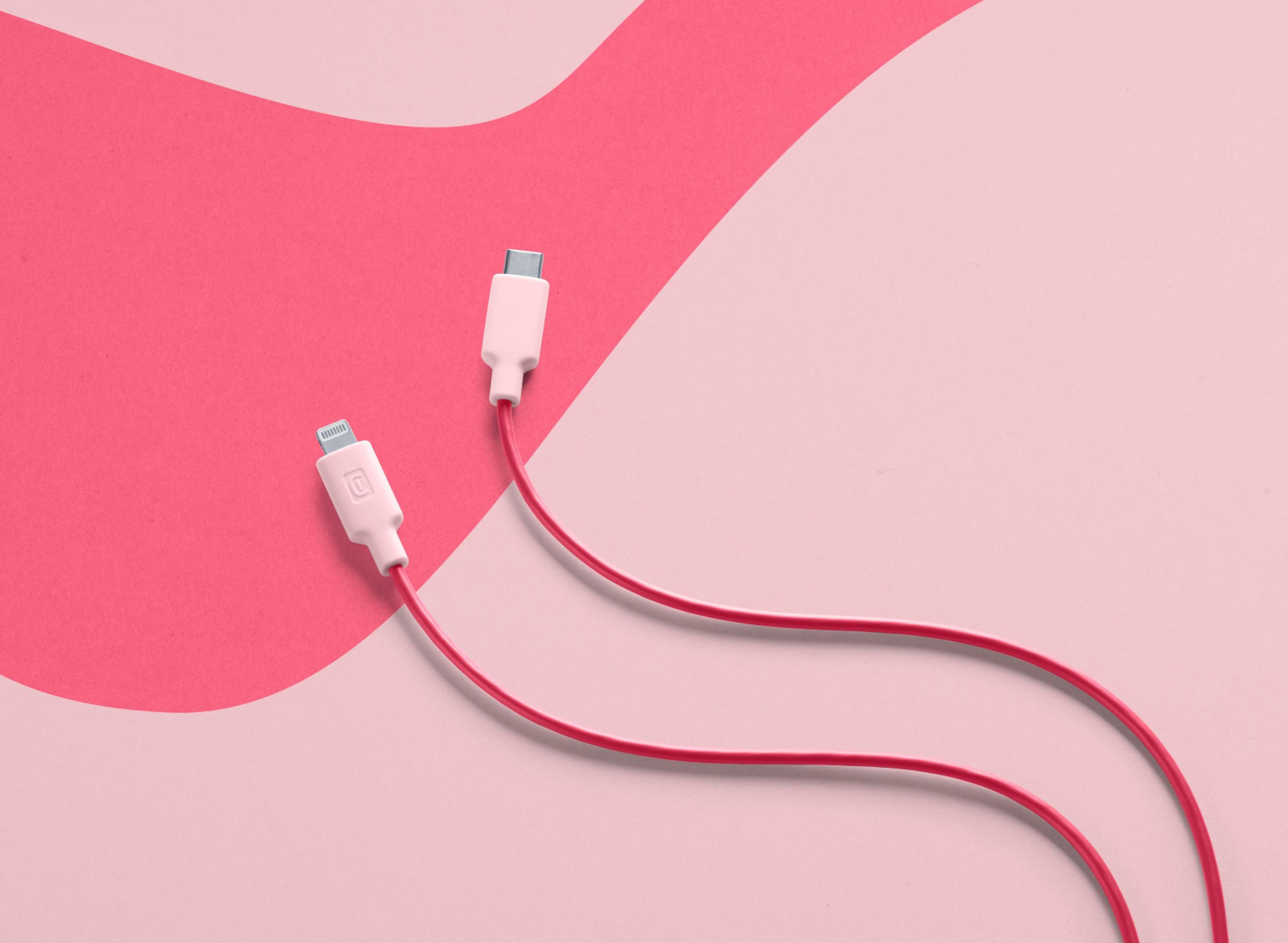 Dos cables de carga blancos con cables rojos sobre fondo rosa.