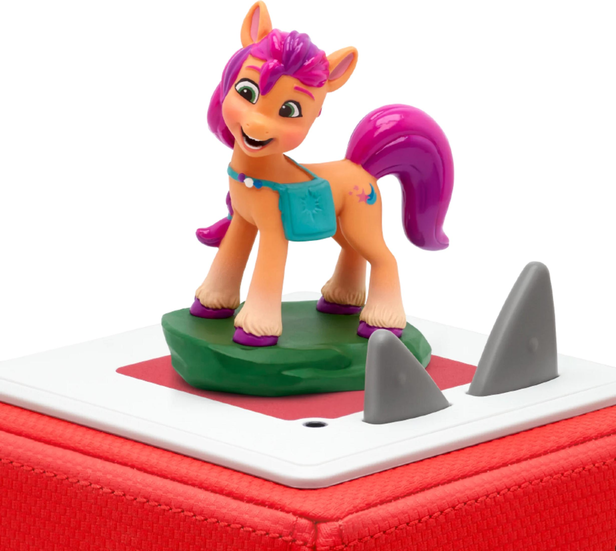 Eine orangefarbene Ponystatue mit violetter Mähne auf grünem Podest.