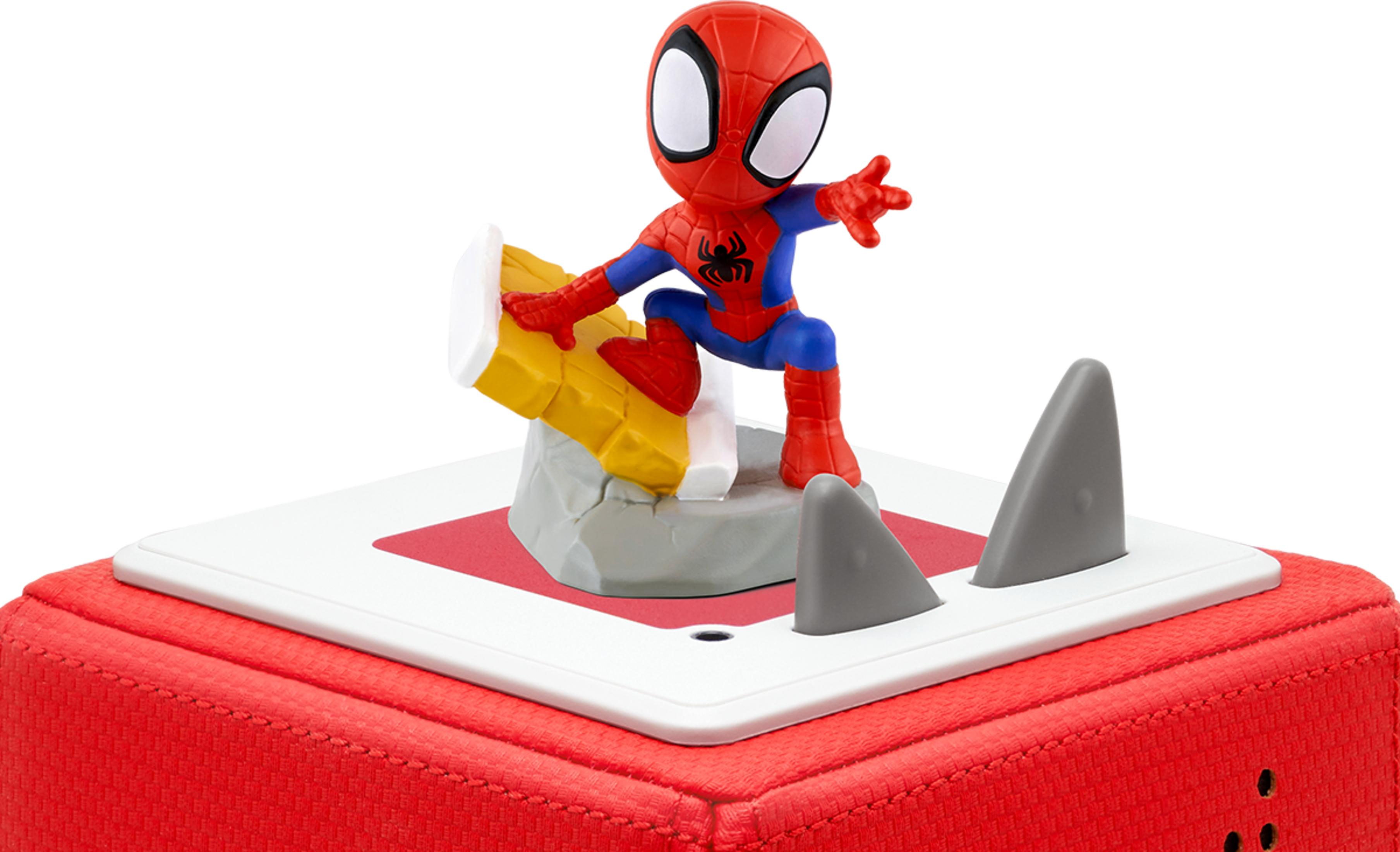 Spiderman-Figur auf einem roten Spielzeugblock mit grauen Haifischflossen.