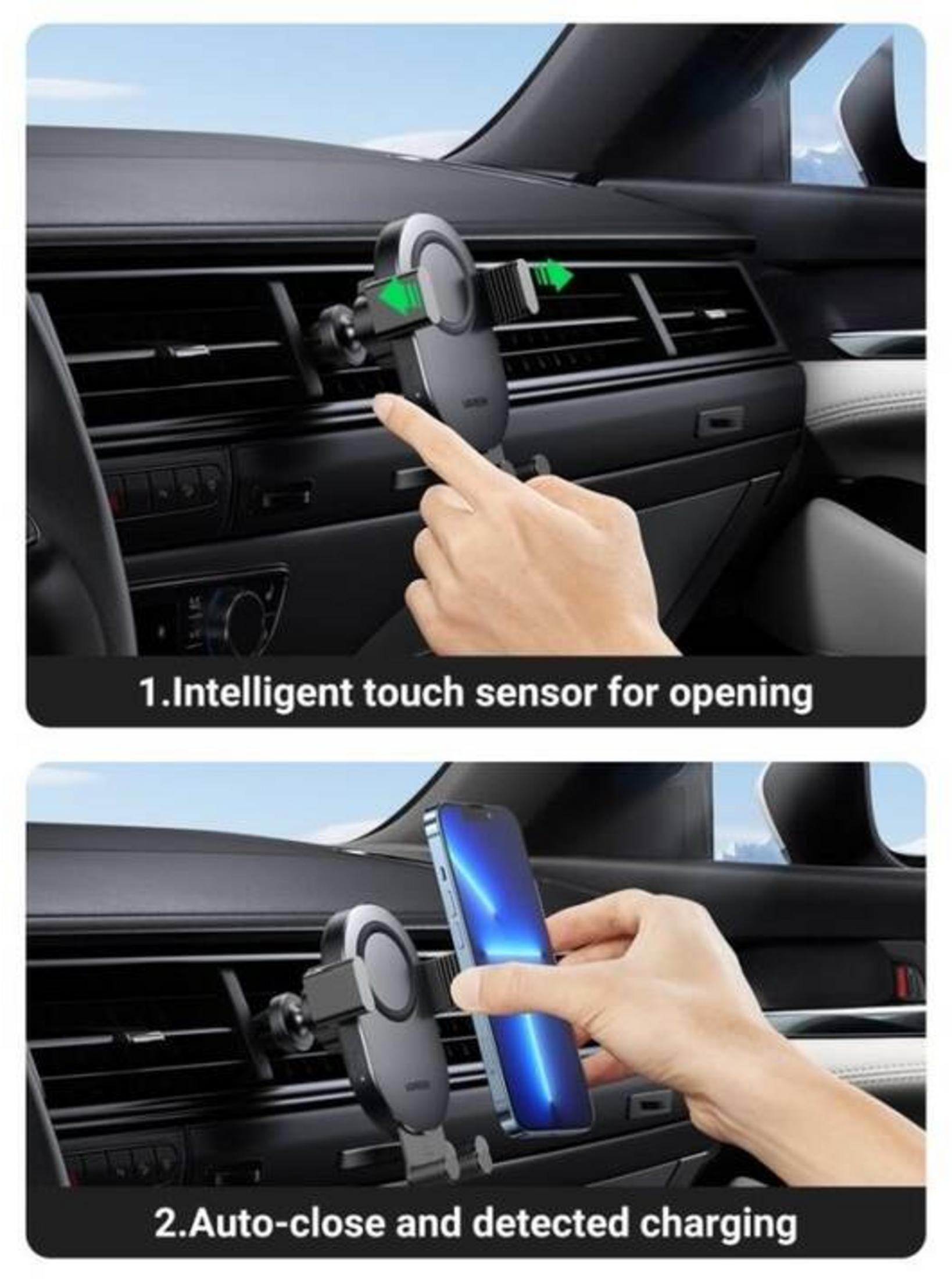 Een hand raakt een telefoonhouder aan een auto-ventilatieopening aan.
