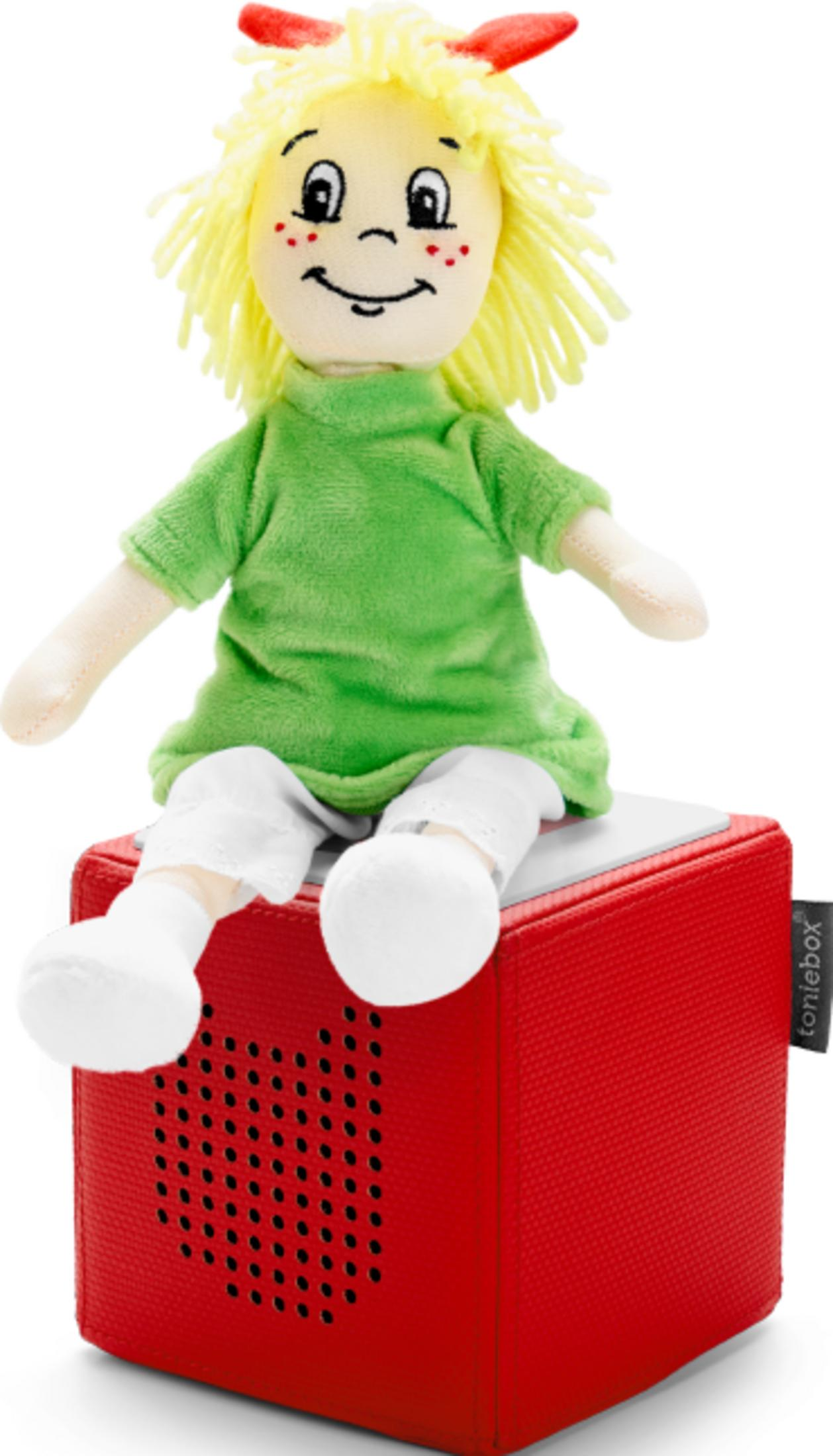 Eine Stoffpuppe mit gelben Haaren sitzt auf einer roten Box.
