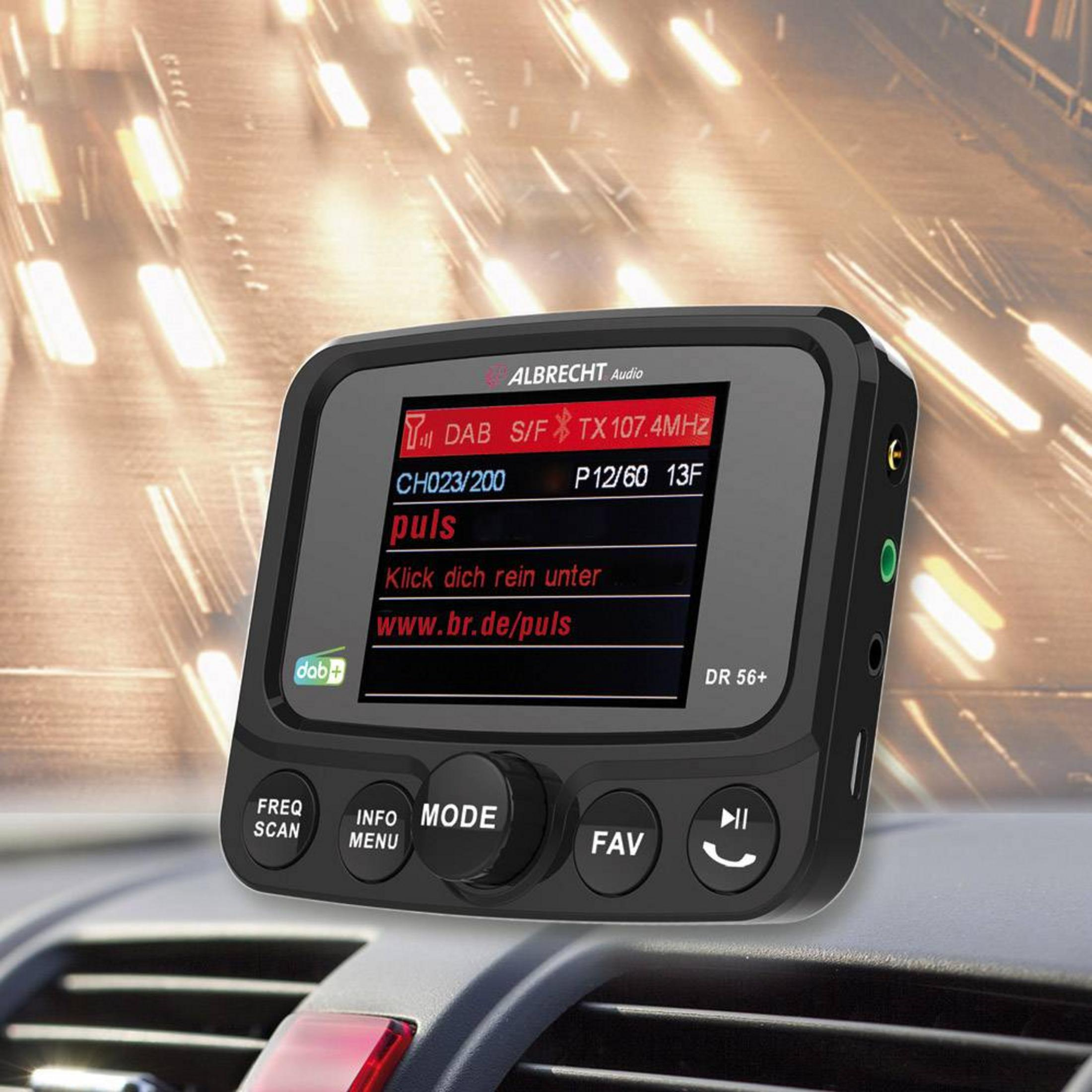 Ein Albrecht Audio DAB+ Radio mit Display und Knöpfen im Auto, unscharfer Hintergrund.