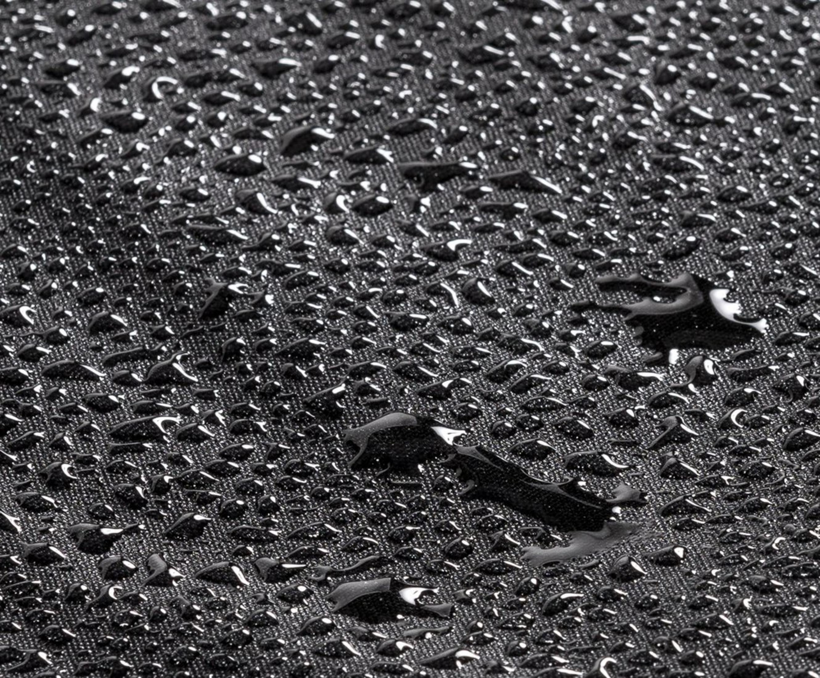 Gocce d'acqua su tessuto nero. Vista ravvicinata.