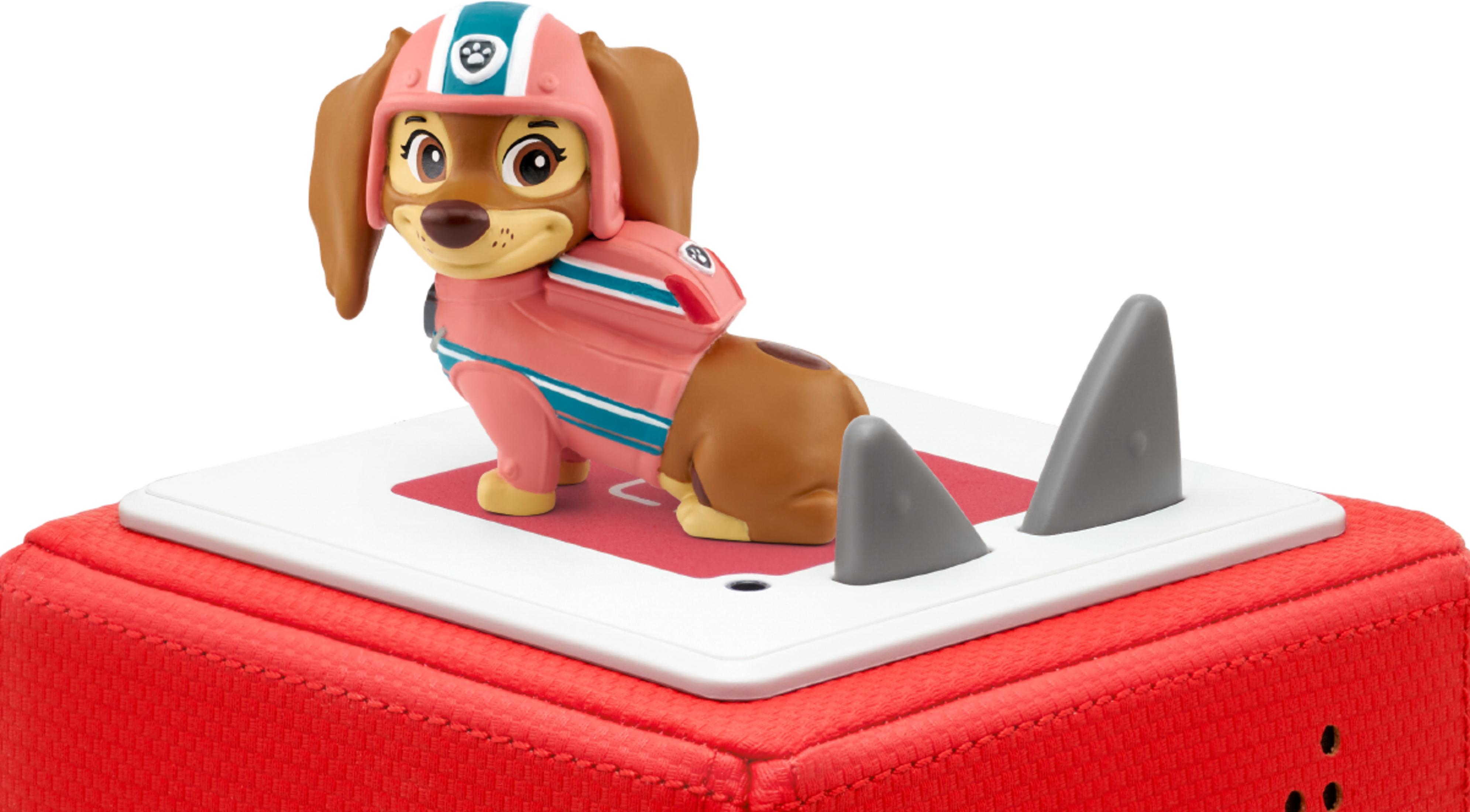 Eine braune Hundefigur in einem rosafarbenen Taucheranzug und Helm auf einer roten Basis.