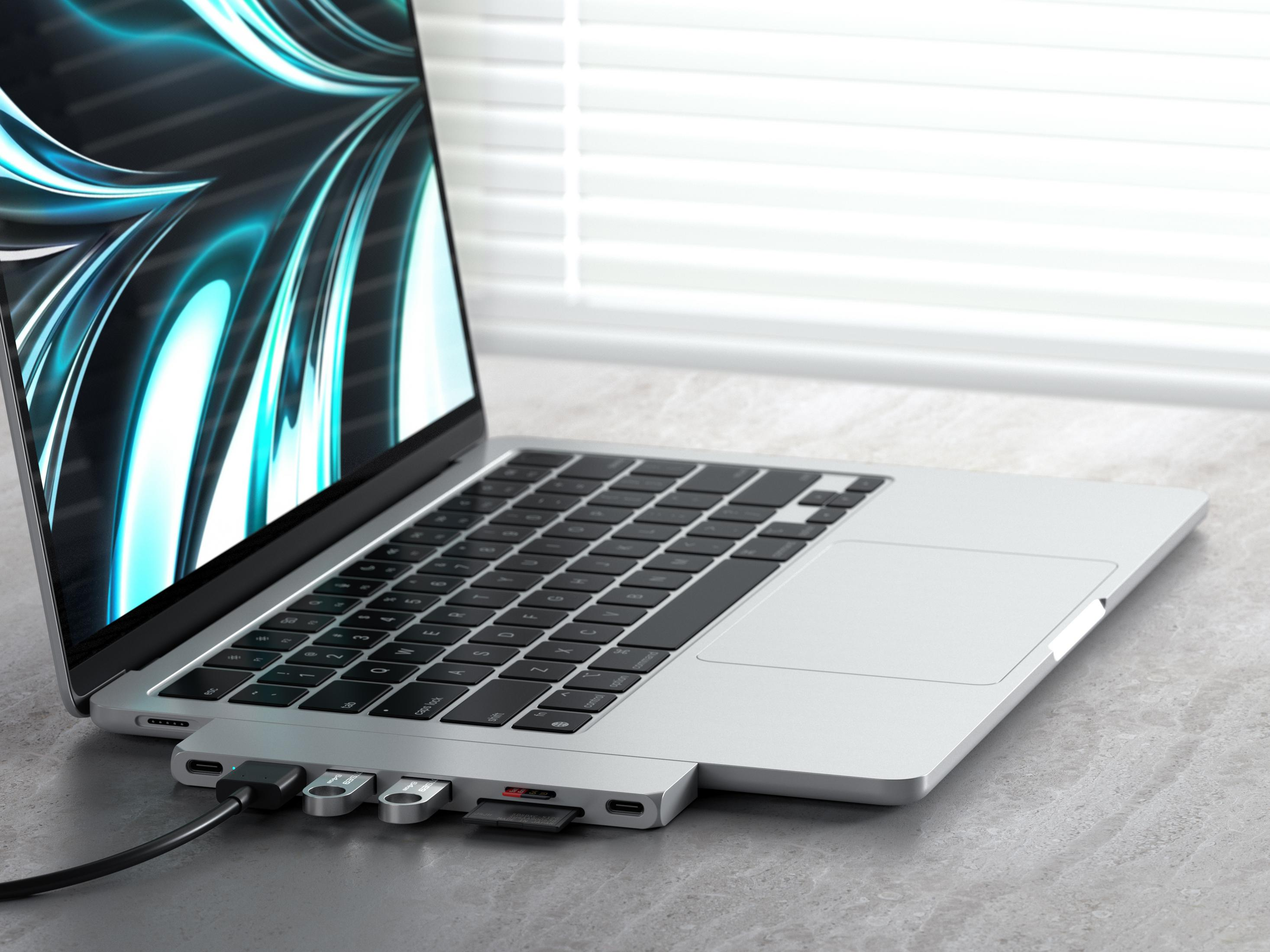 Un portátil con hub USB-C, tarjeta SD y memorias USB conectadas.