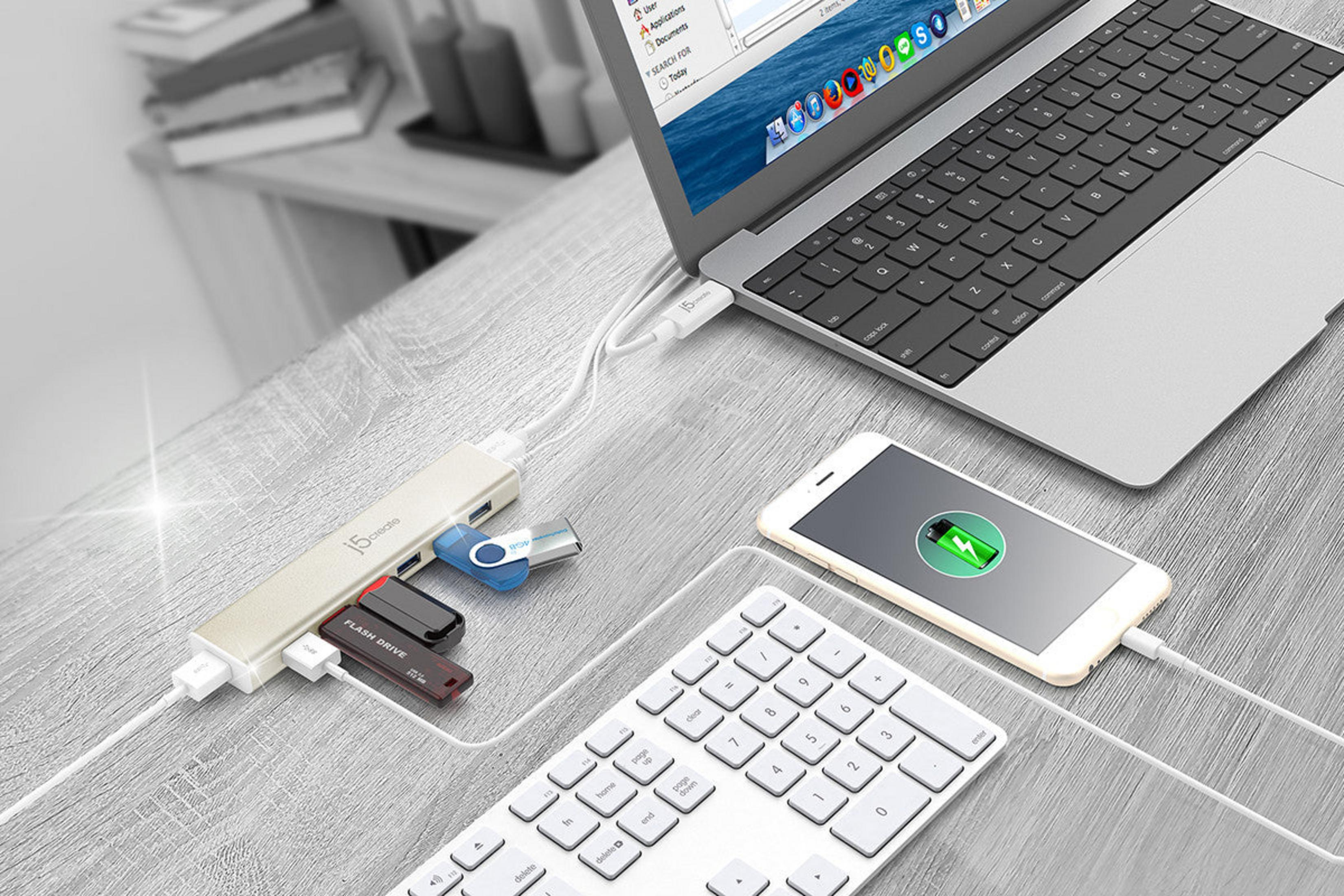 Ein Laptop, eine Tastatur, ein Smartphone und ein USB-Hub mit Flash-Laufwerken.