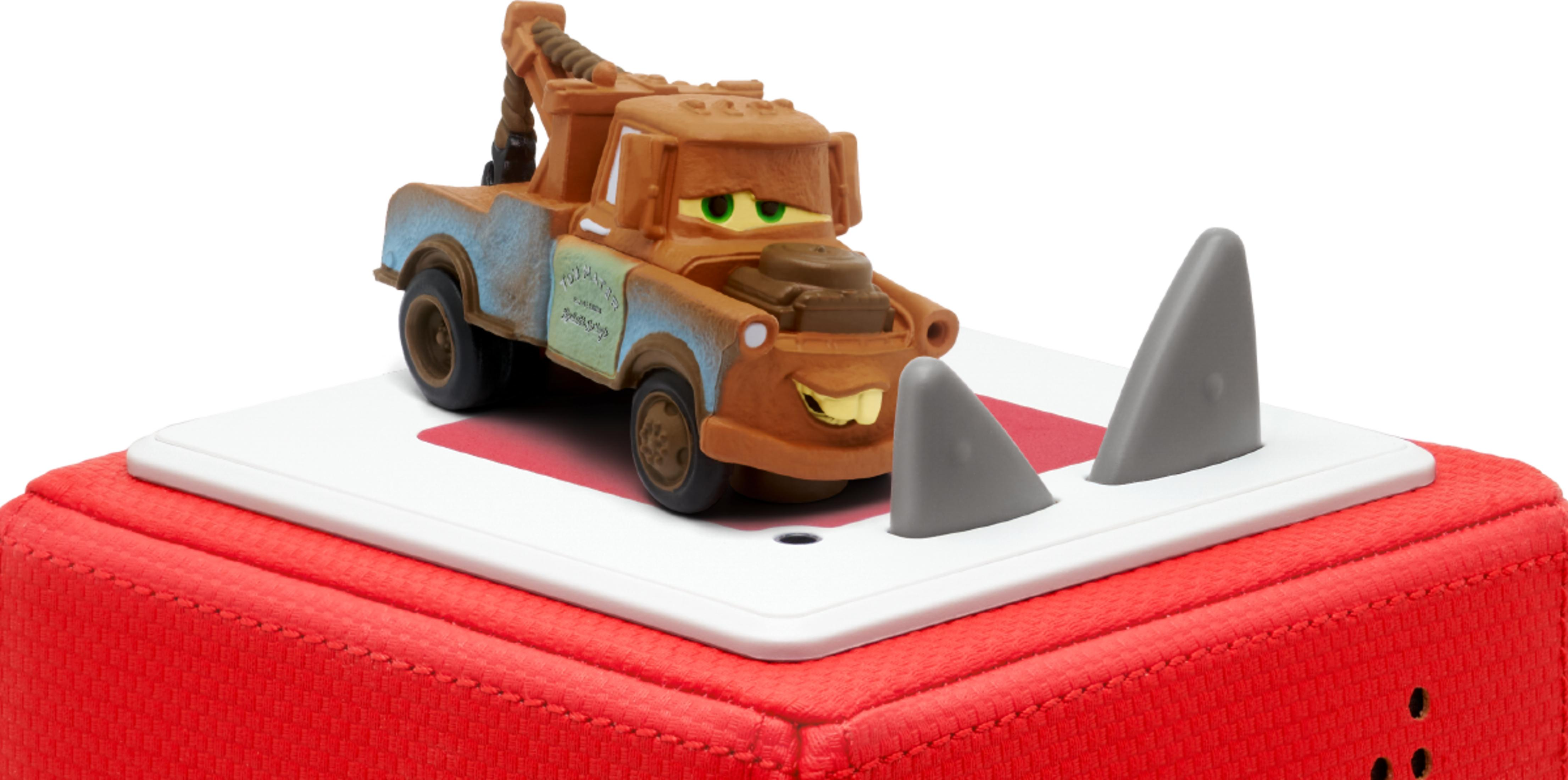 Ein Spielzeugauto von Mater steht auf einer roten und weißen Plattform mit grauen Haifischflossen.