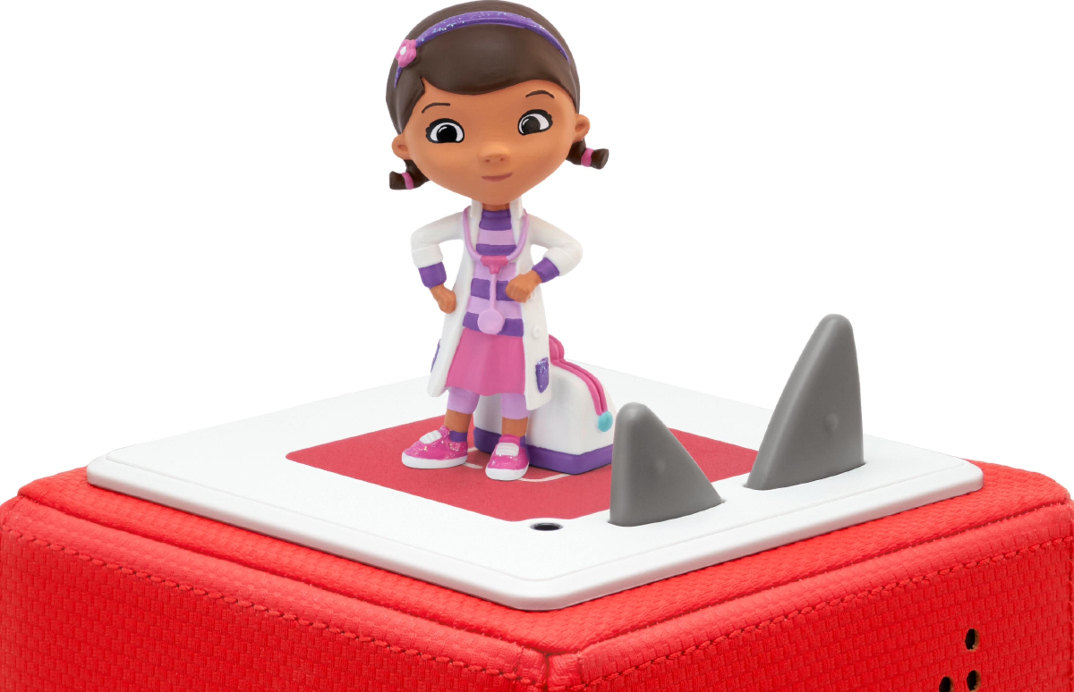 Eine Figur von Doc McStuffins steht auf einem roten Würfel mit Haifischflossen.