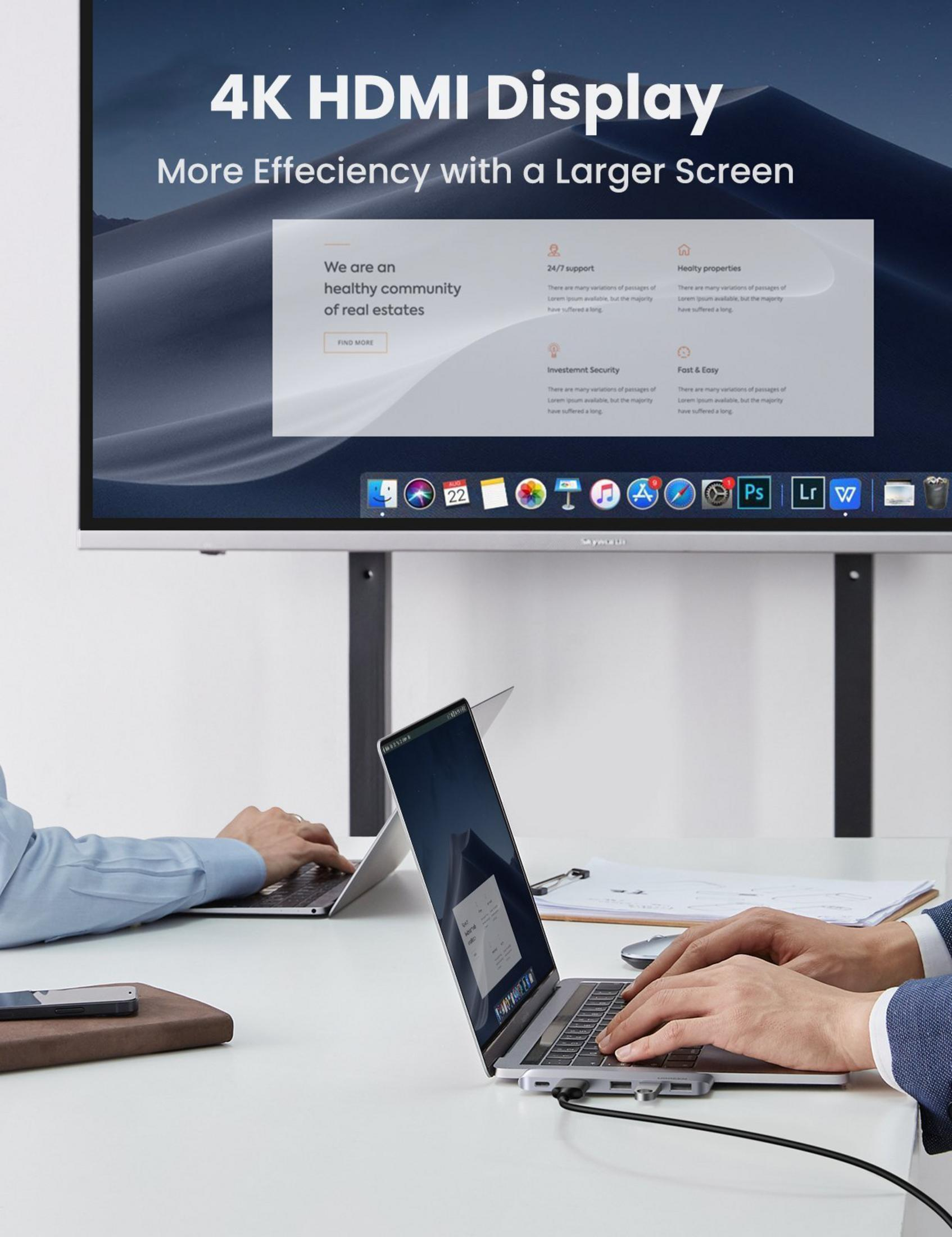 Mężczyźni pracują na laptopach przed wyświetlaczem 4K pokazującym stronę internetową.