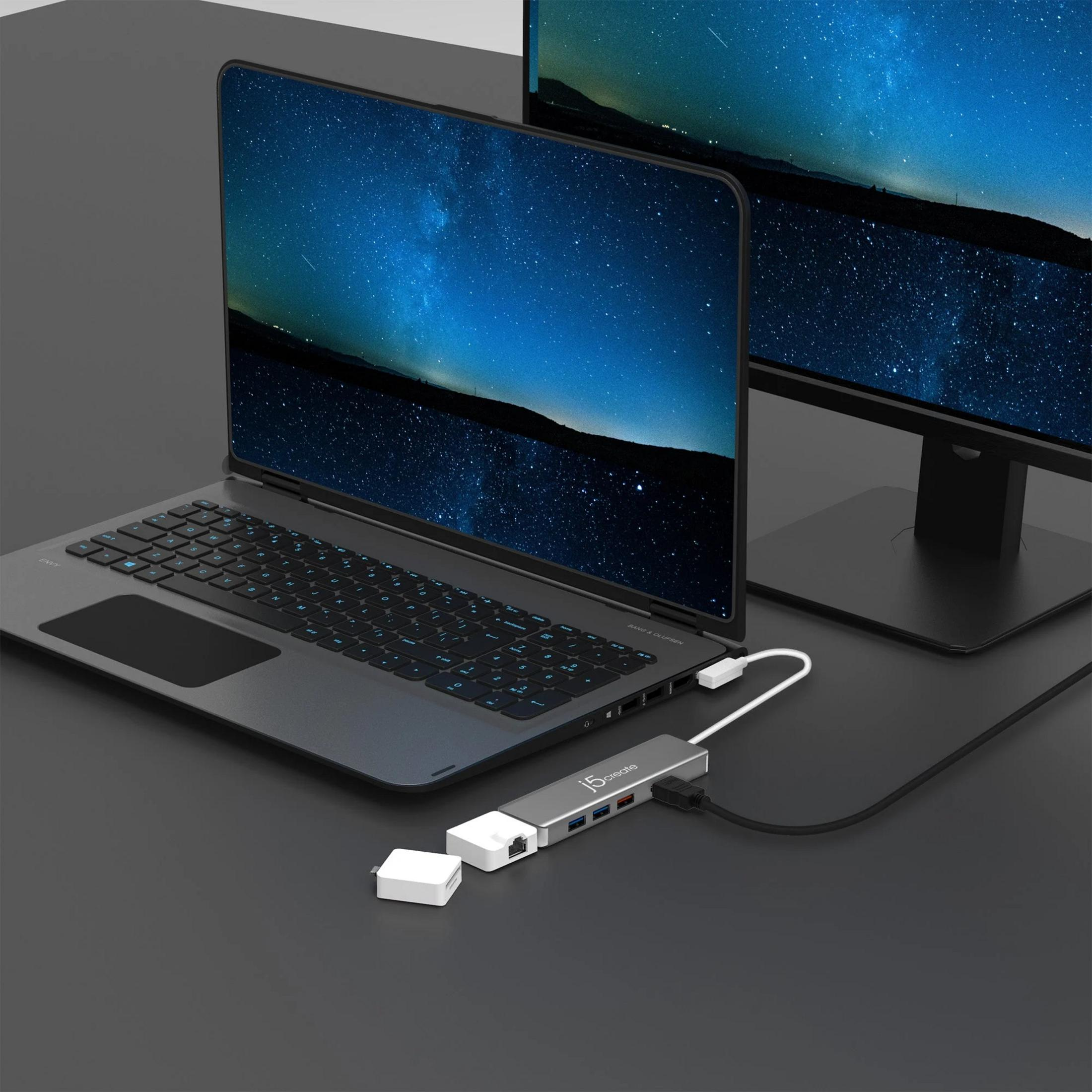 Ein Laptop und Monitor mit Sternenhimmel-Hintergrund, verbunden mit einem USB-Hub.