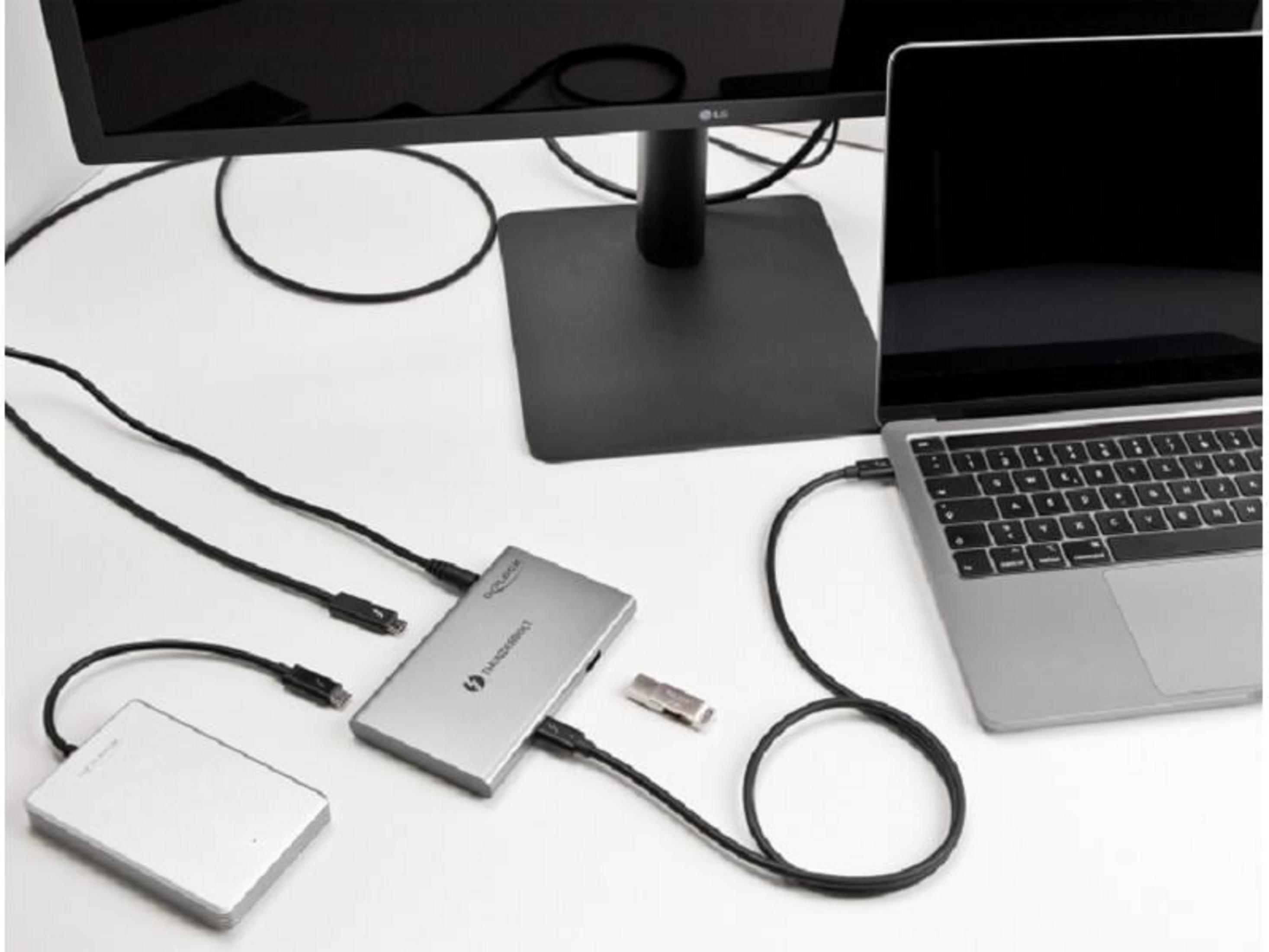 Laptop con dispositivi esterni e monitor su una scrivania bianca.