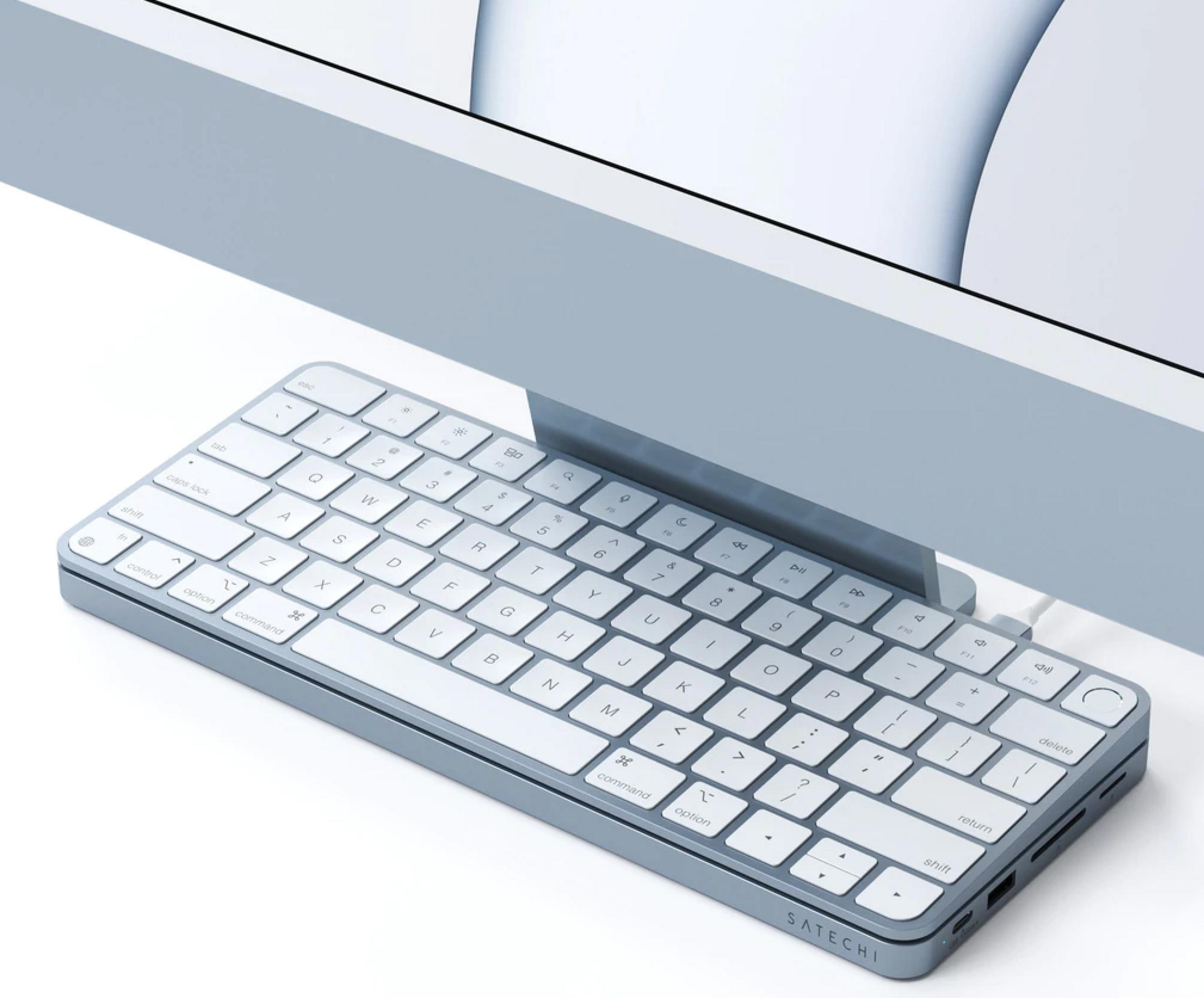 Ein graues Satechi-Keyboard mit weißen Tasten liegt vor einem hellblauen Monitor.