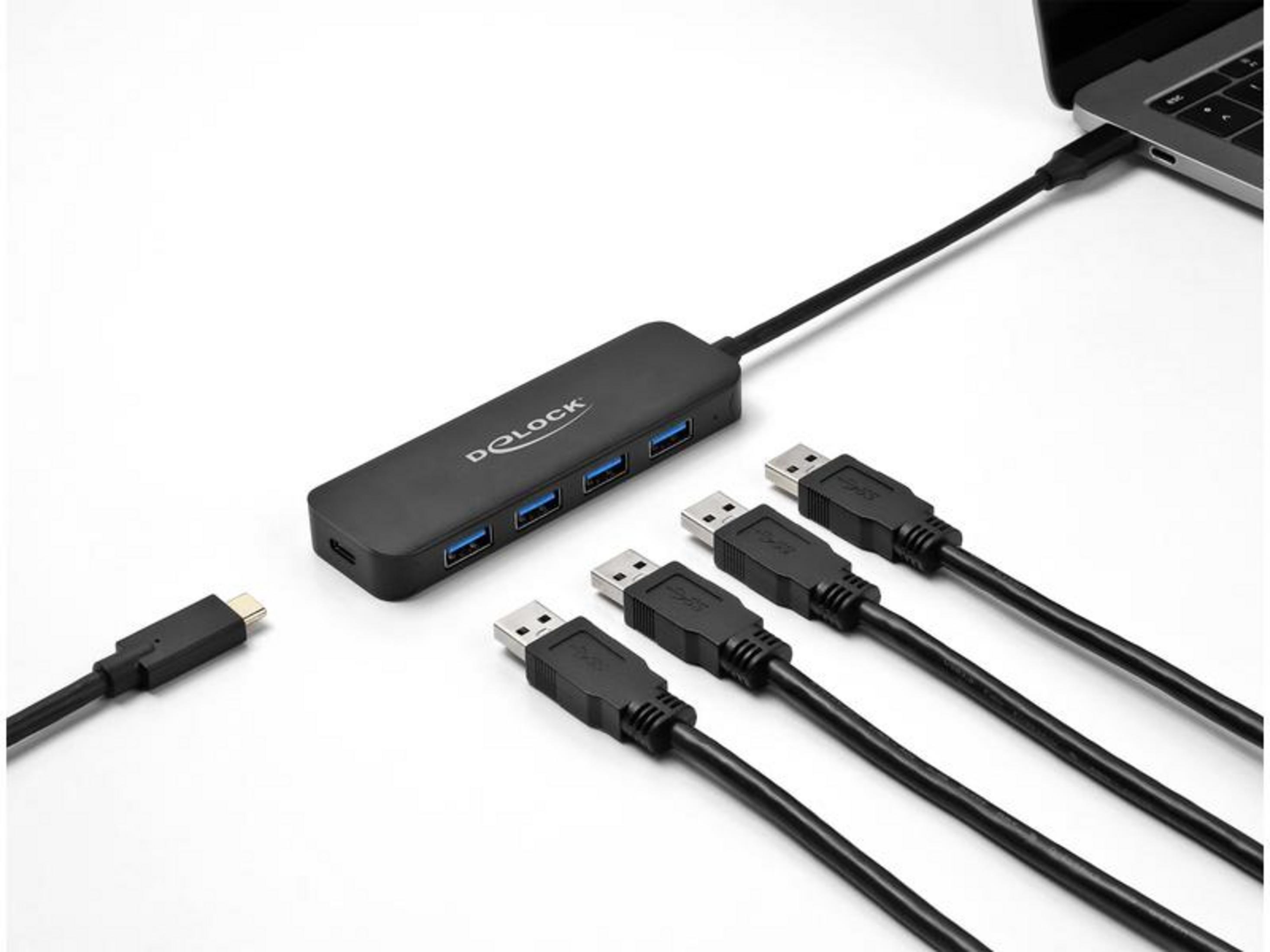 Un hub USB-C nero con quattro porte USB-A è collegato a un laptop.