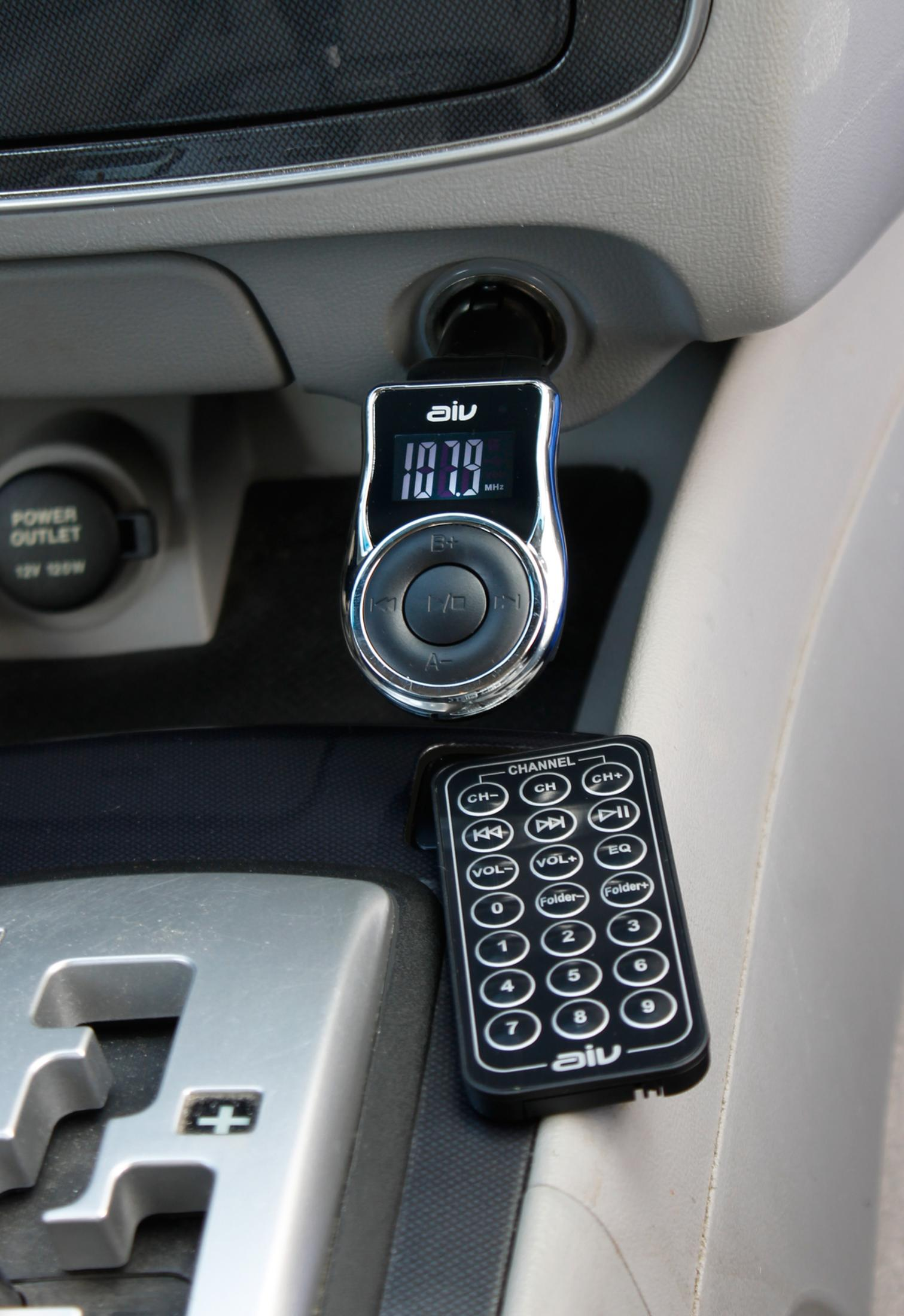 Armaturenbrett im Auto mit FM-Sender, Fernbedienung und Steckdose.