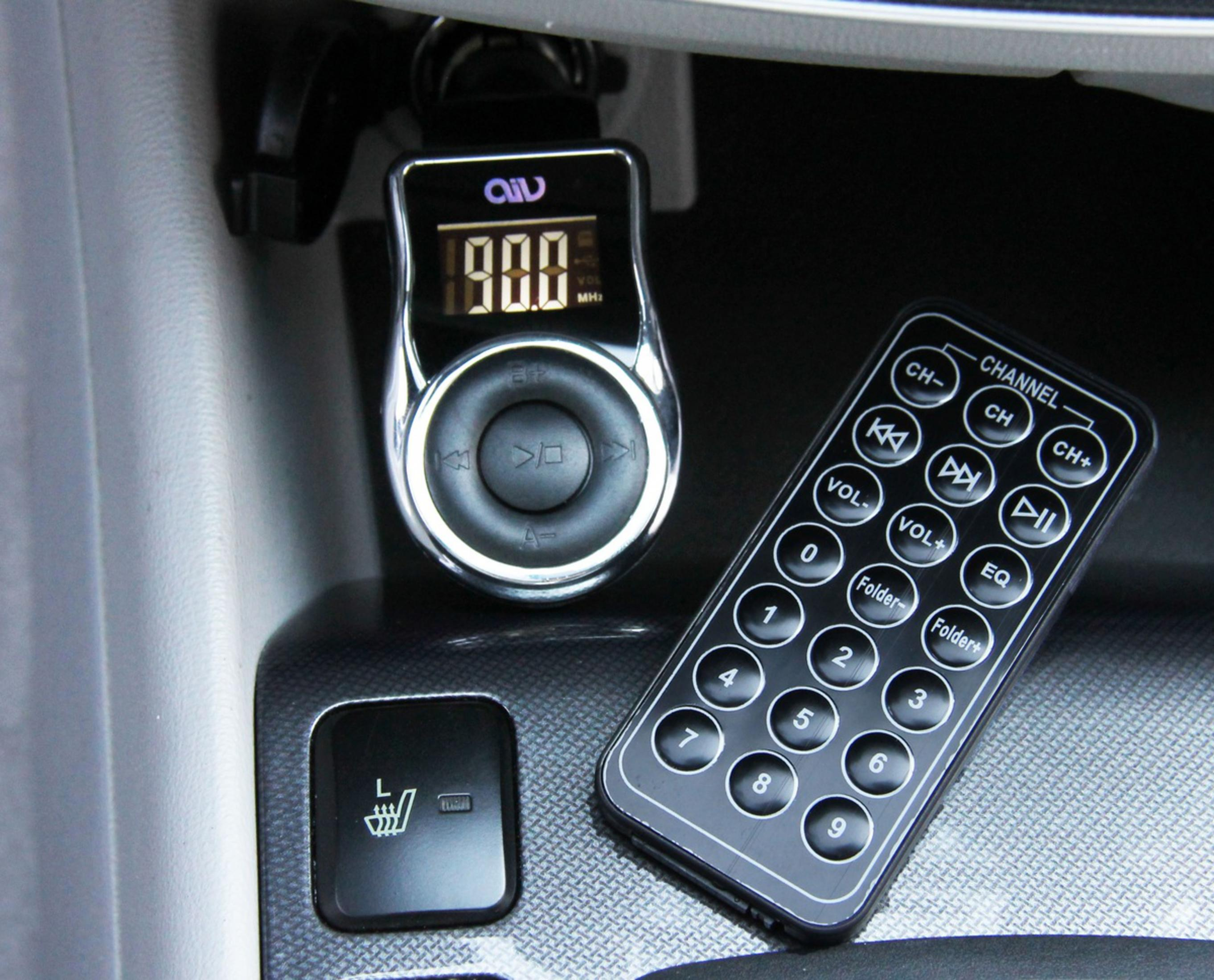 Ein FM-Sender und eine Fernbedienung auf dem Armaturenbrett eines Autos.