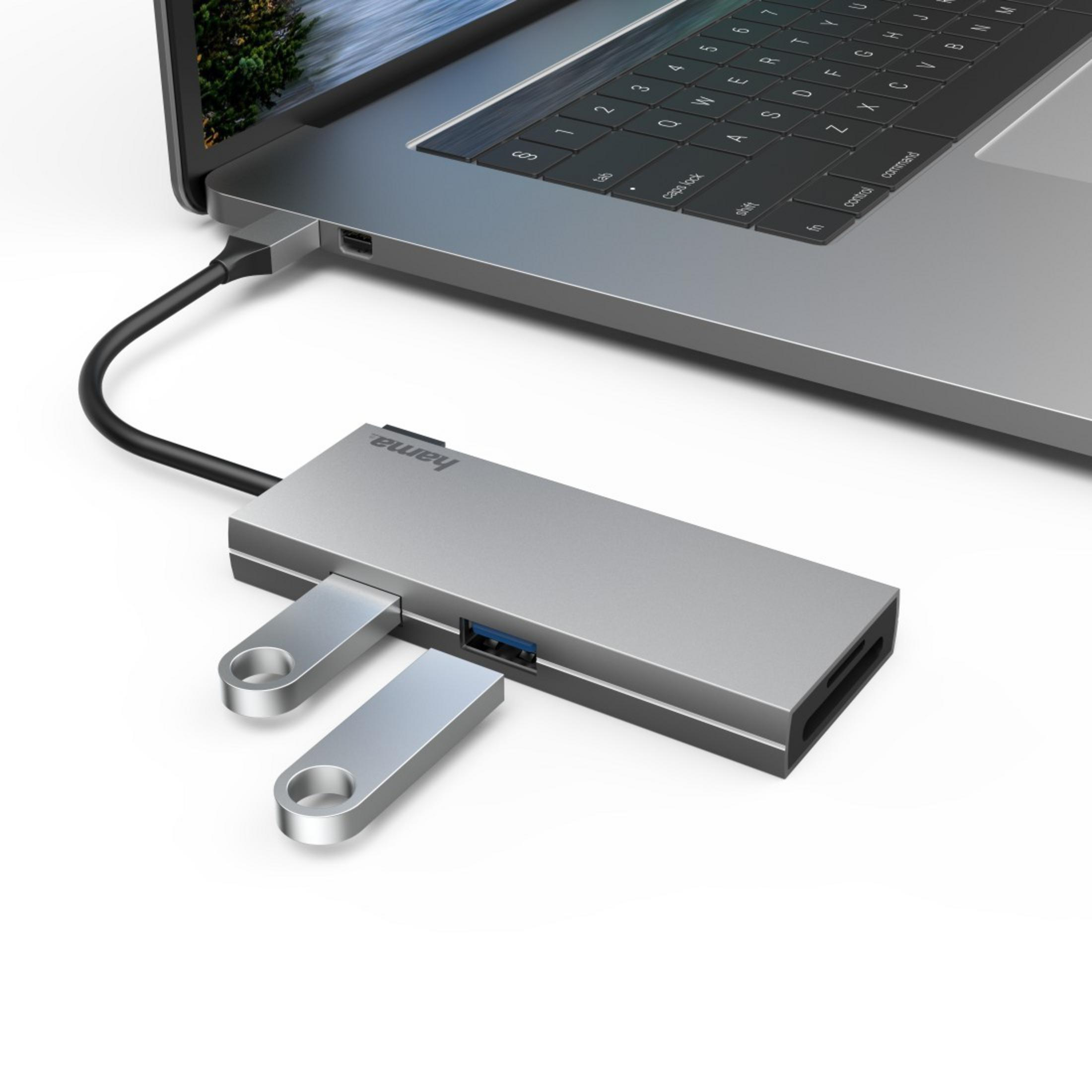Hub USB-C argento con due chiavette USB inserite e tastiera laptop.