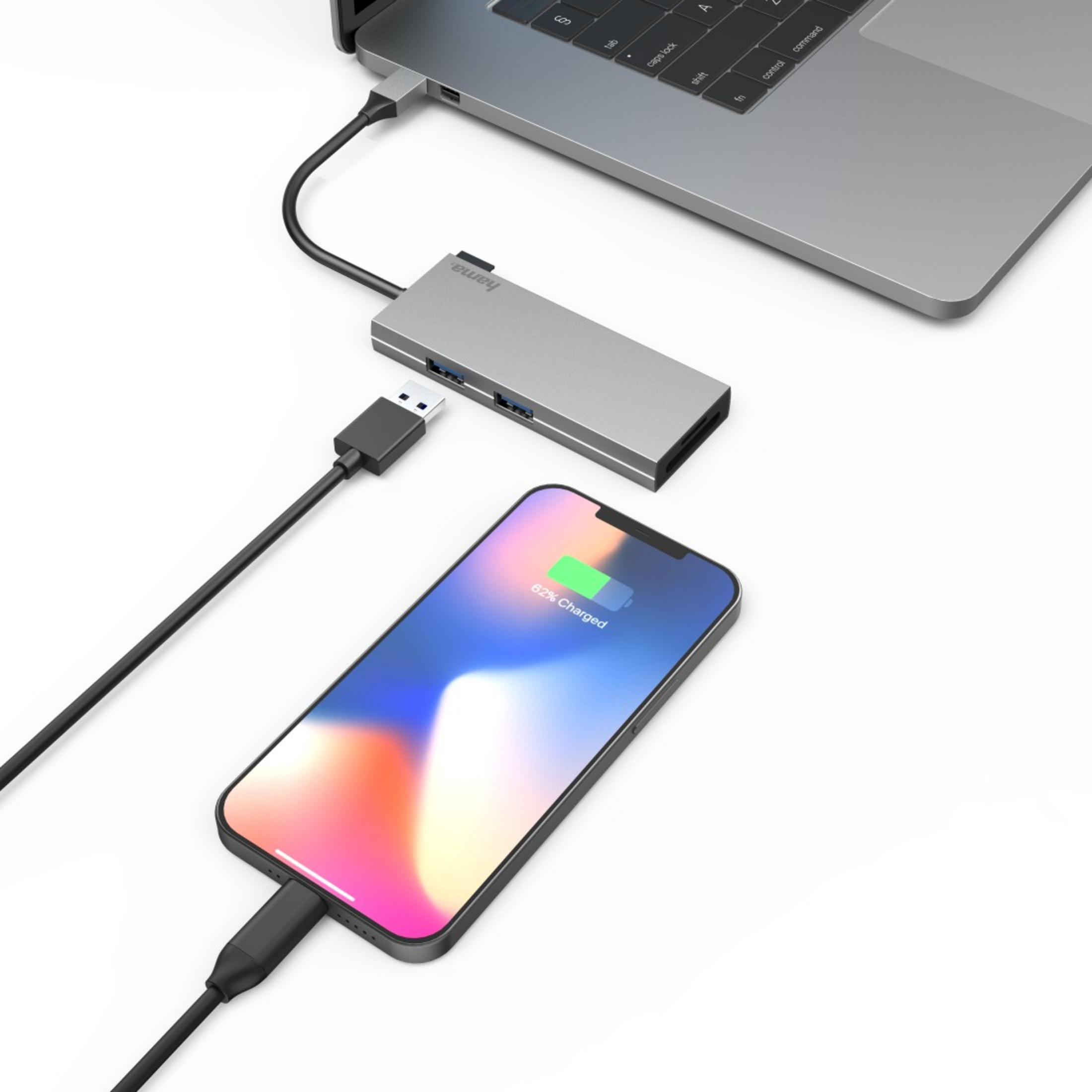 Un laptop si collega a un hub USB che sta caricando uno smartphone.
