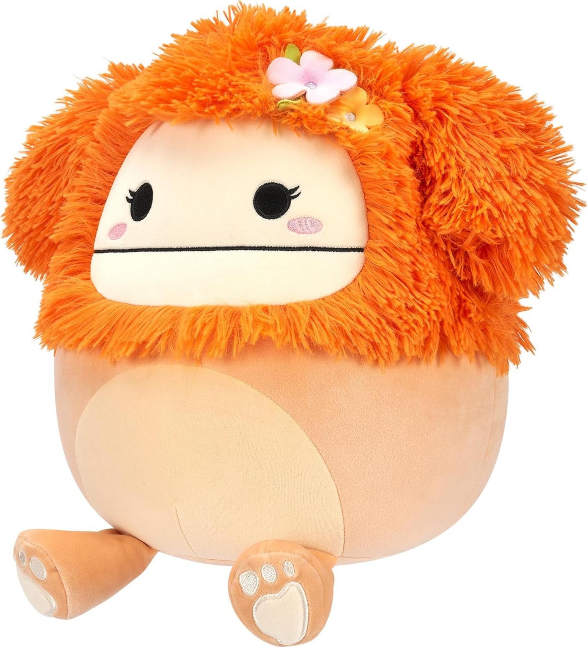 Un lion en peluche orange avec des fleurs dans la fourrure sur fond blanc.