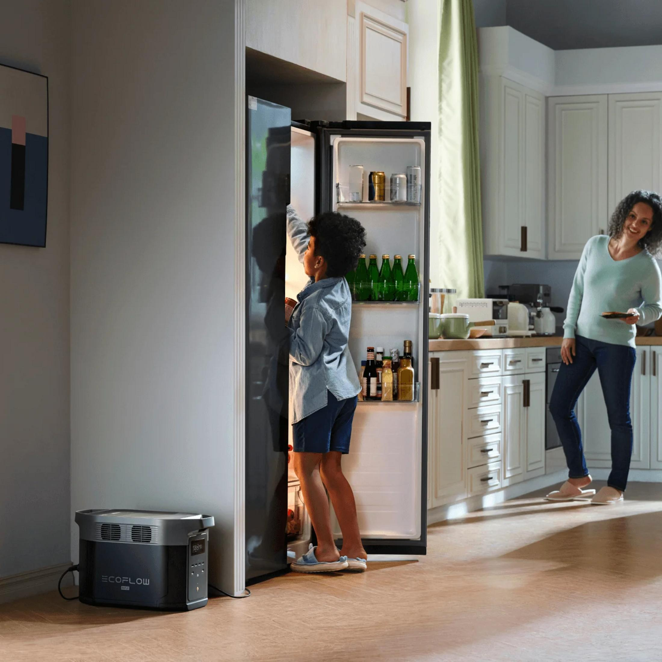Dziecko sięga do otwartej lodówki, kobieta obok. Generator prądu z przodu.