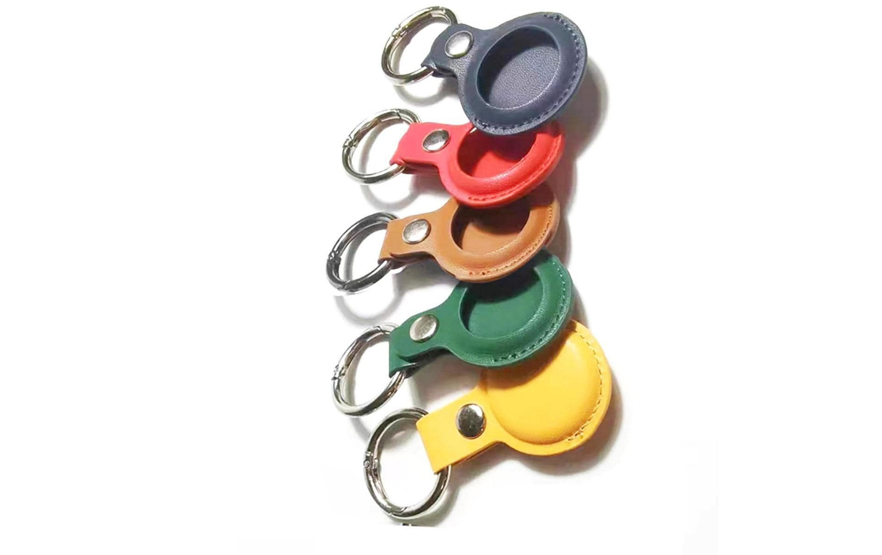 Cinq porte-clés colorés avec anneaux argentés sur fond blanc.