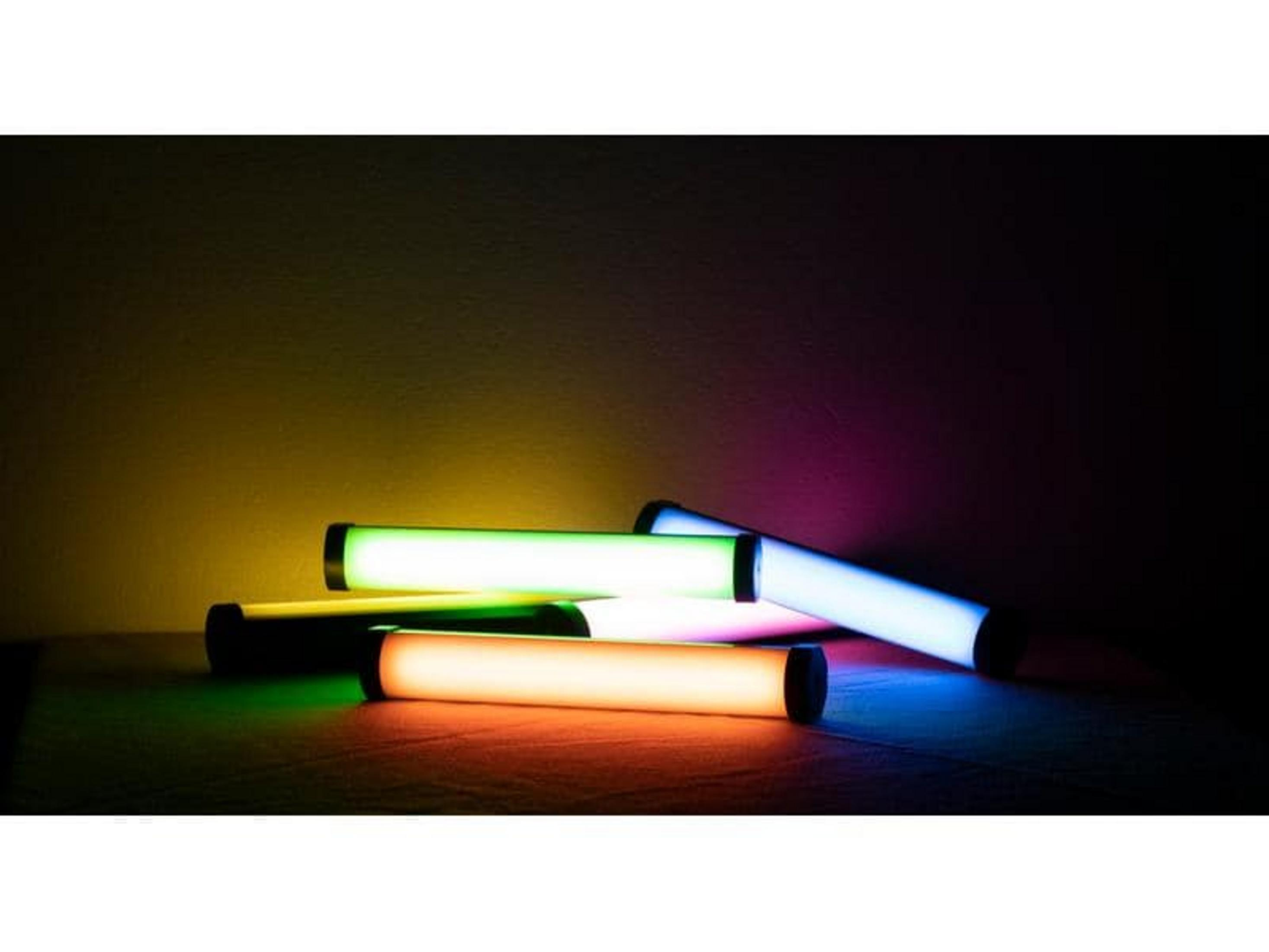 Plusieurs tubes lumineux bleus, verts, oranges et blancs reposent sur une surface sombre.