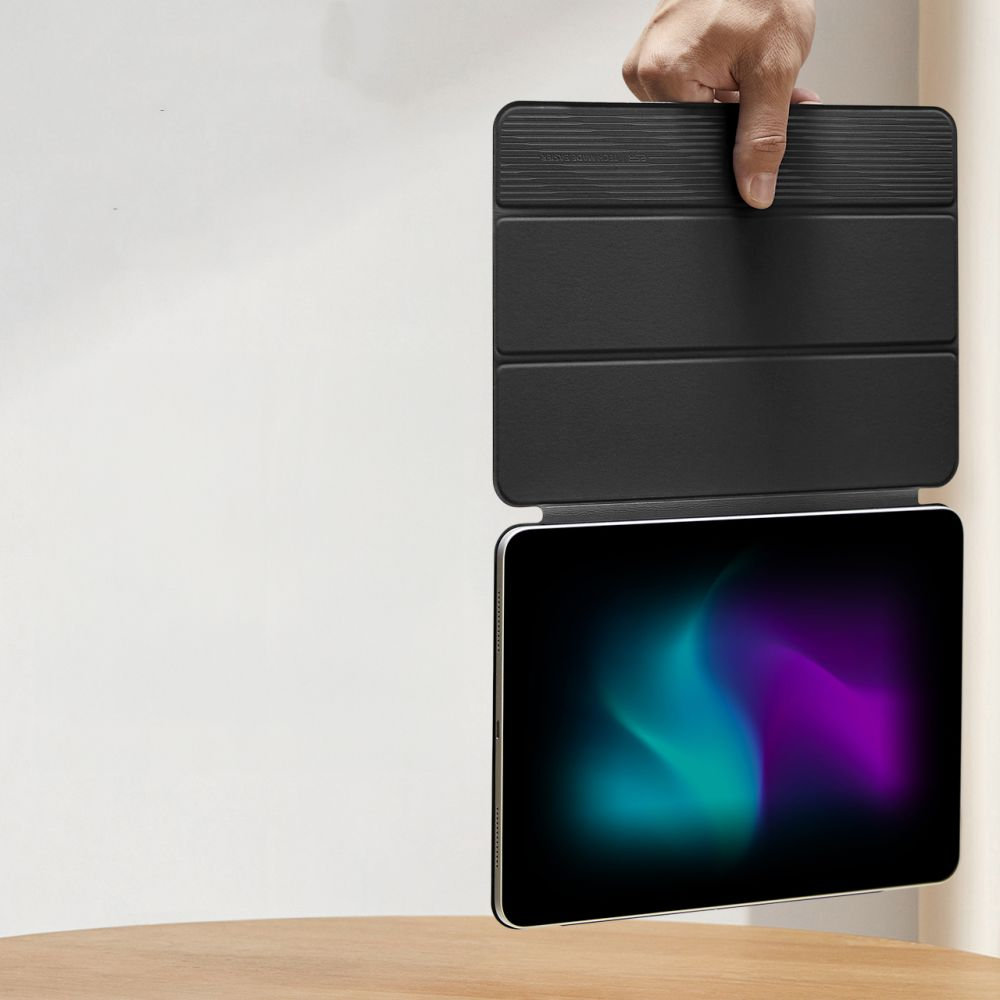 Eine Hand hält ein schwarzes Tablet mit einem Farbverlauf-Hintergrundbild.