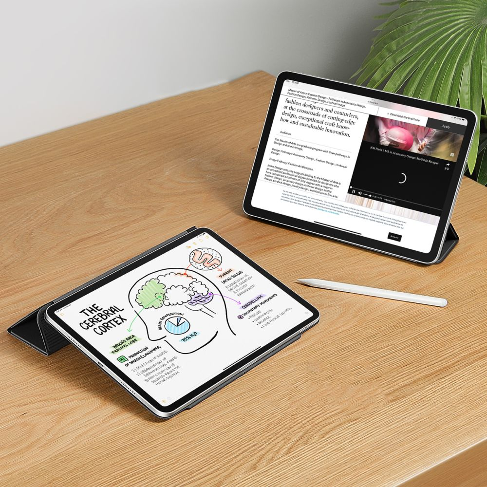 Zwei Tablets auf einem Holztisch, eines zeigt eine Gehirnskizze, das andere eine Webseite.