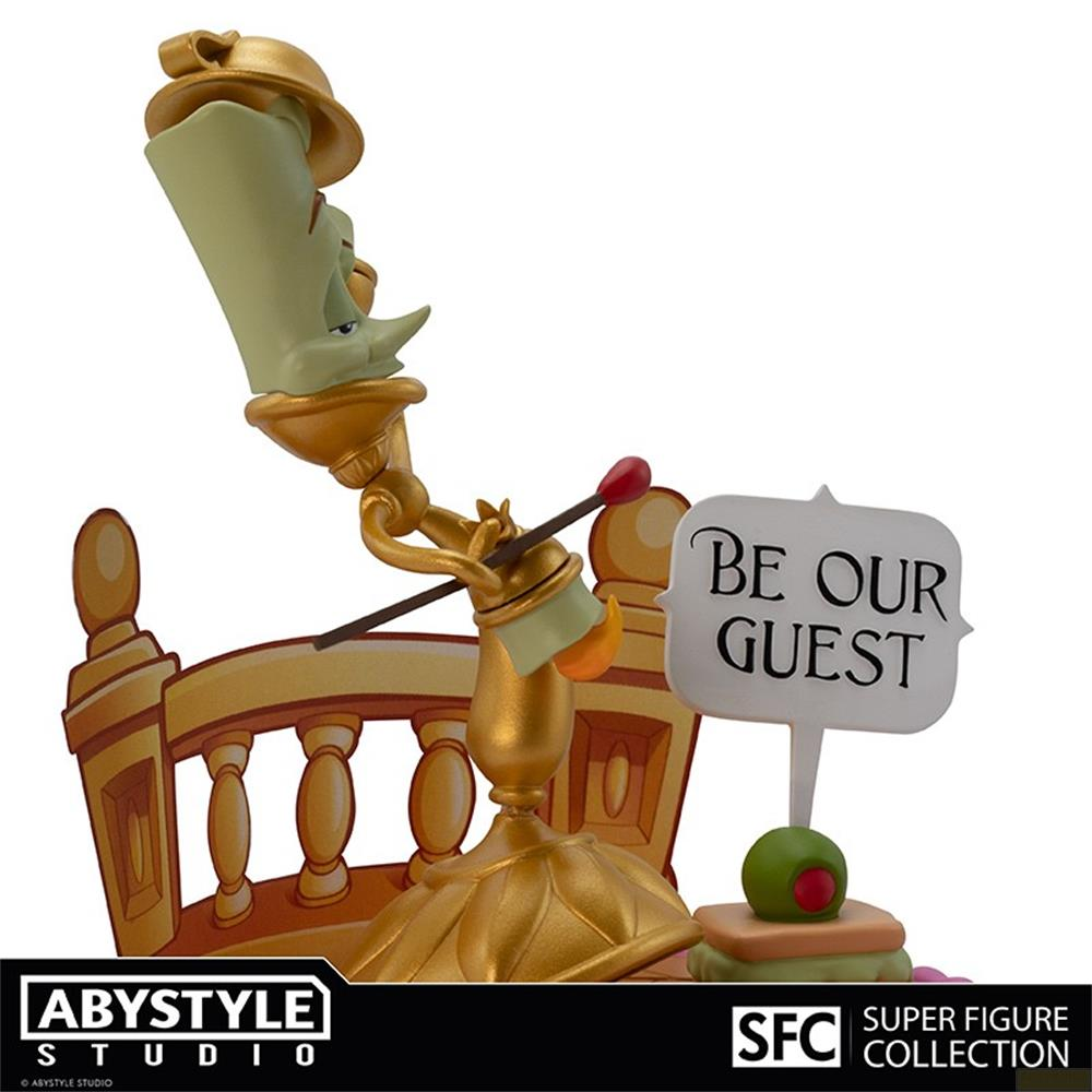 Figura de candelabro dorado con un cartel "BE OUR GUEST".
